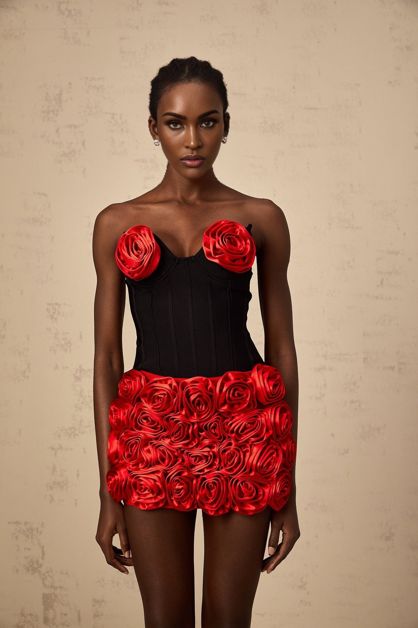 A woman wearing a red twopiece outfit consisting of a top and skirt with rose applique designs matching set