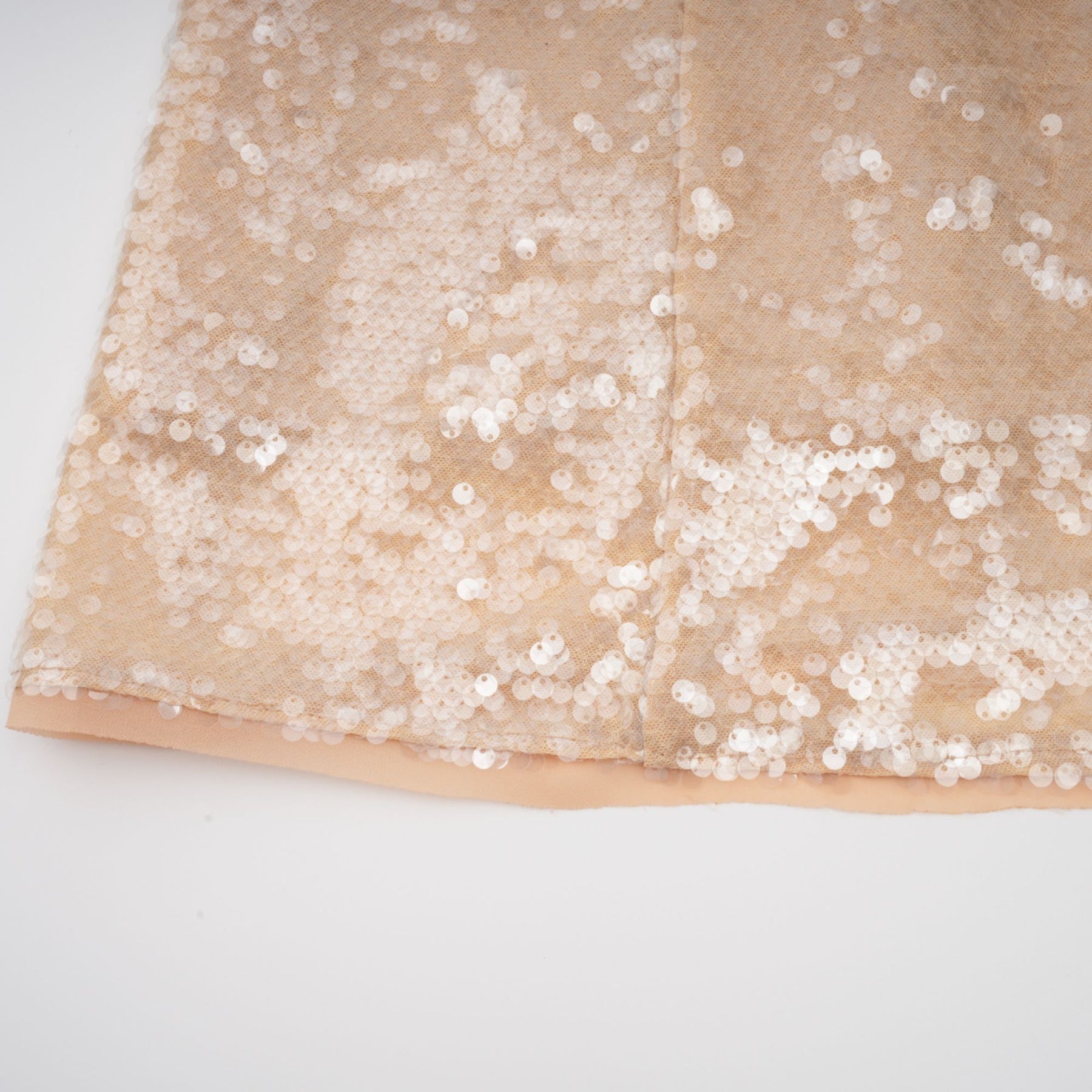 A woman wearing a shimmering midi dress adorned with faux pearls and sequins elegant formal attire with a luxurious sparkle