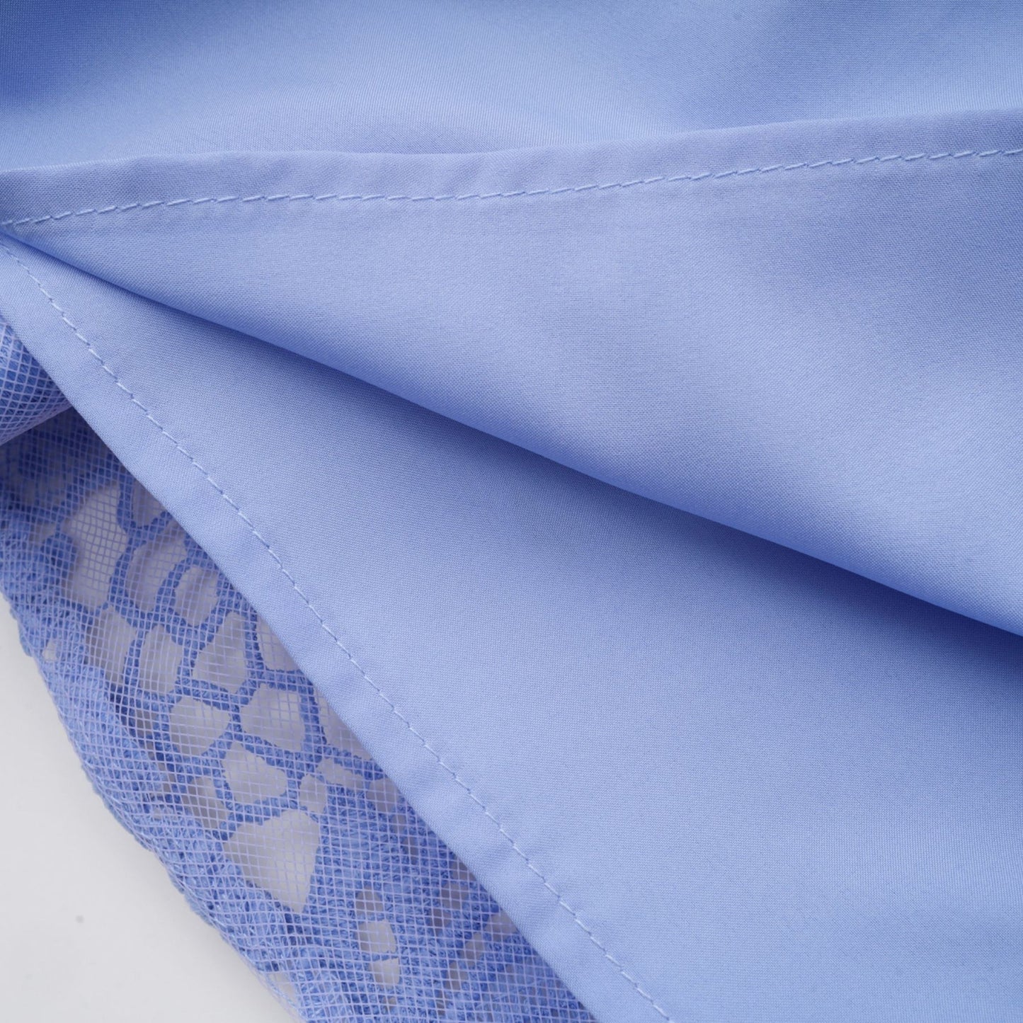 A woman wearing a short Gaelle dress with a V neckline and floral embroidery details