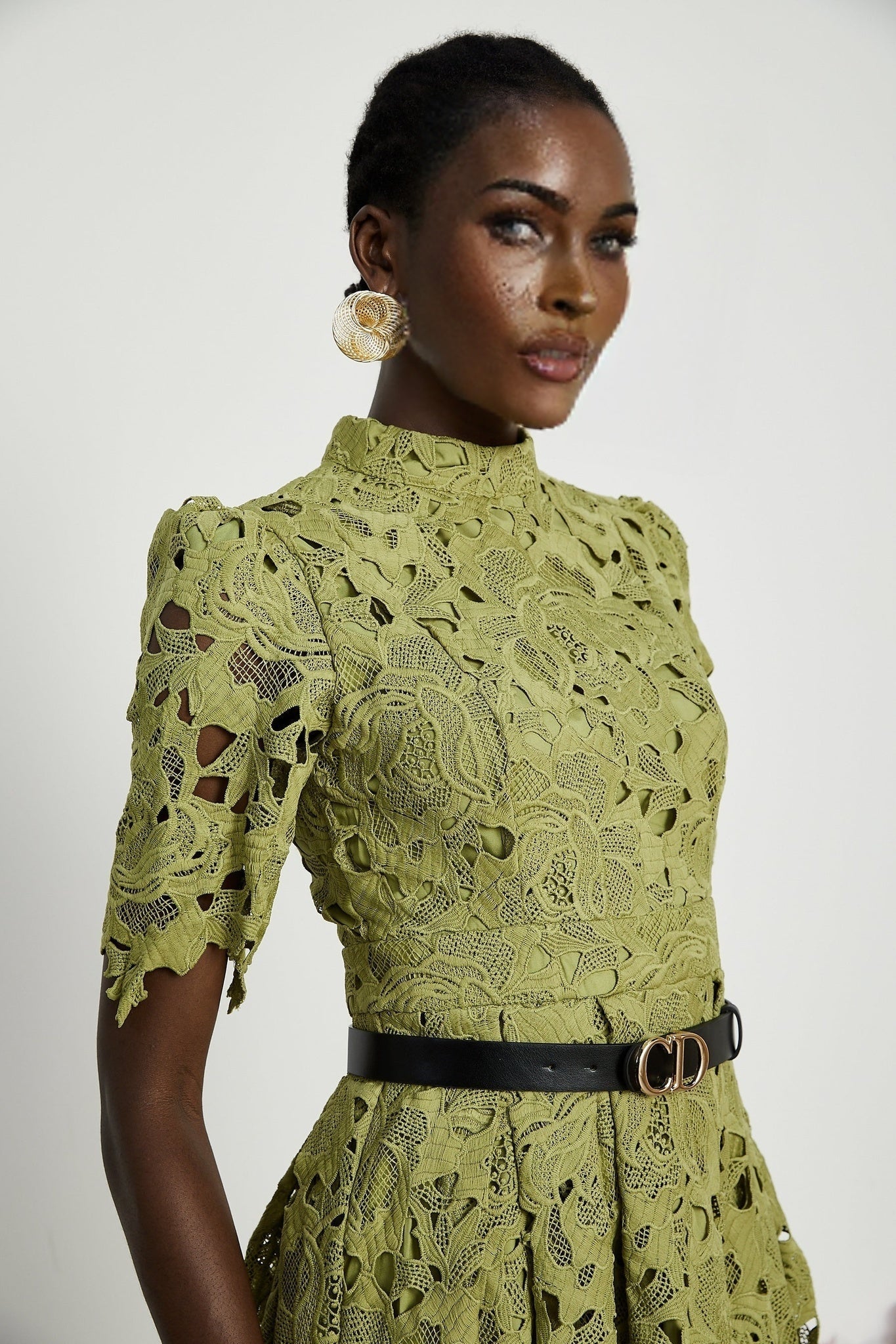 A woman wearing a short white embroidered dress with cutout details named Valerie