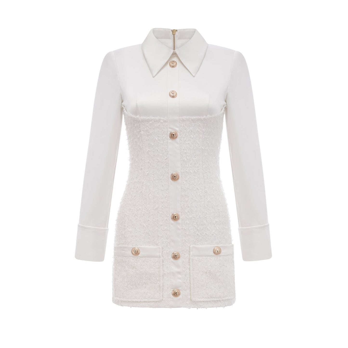 A woman wearing a white mini dress with short sleeves and a single row of buttons down the front standing against a plain background