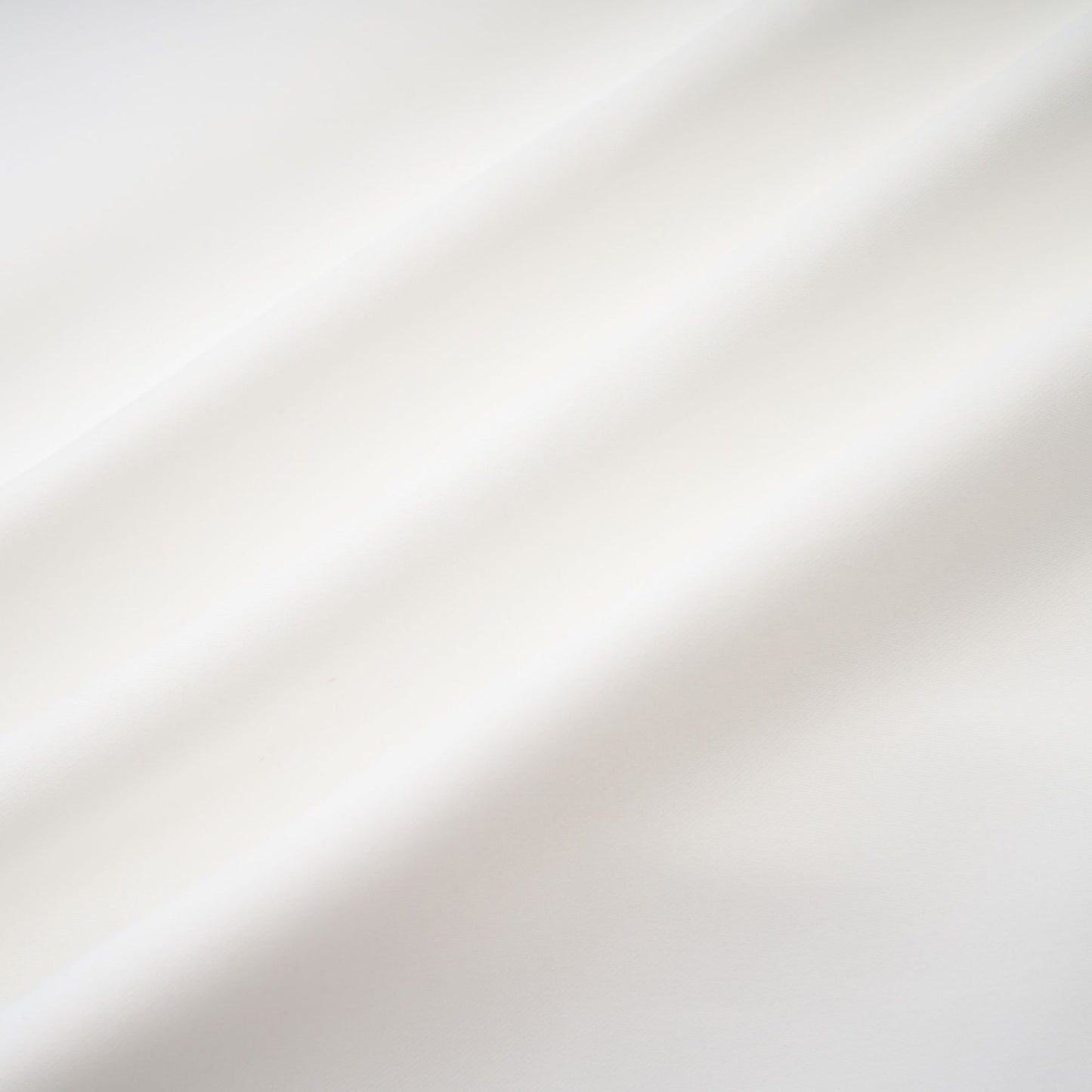 A woman wearing a white off the shoulder dress with a flowing silhouette