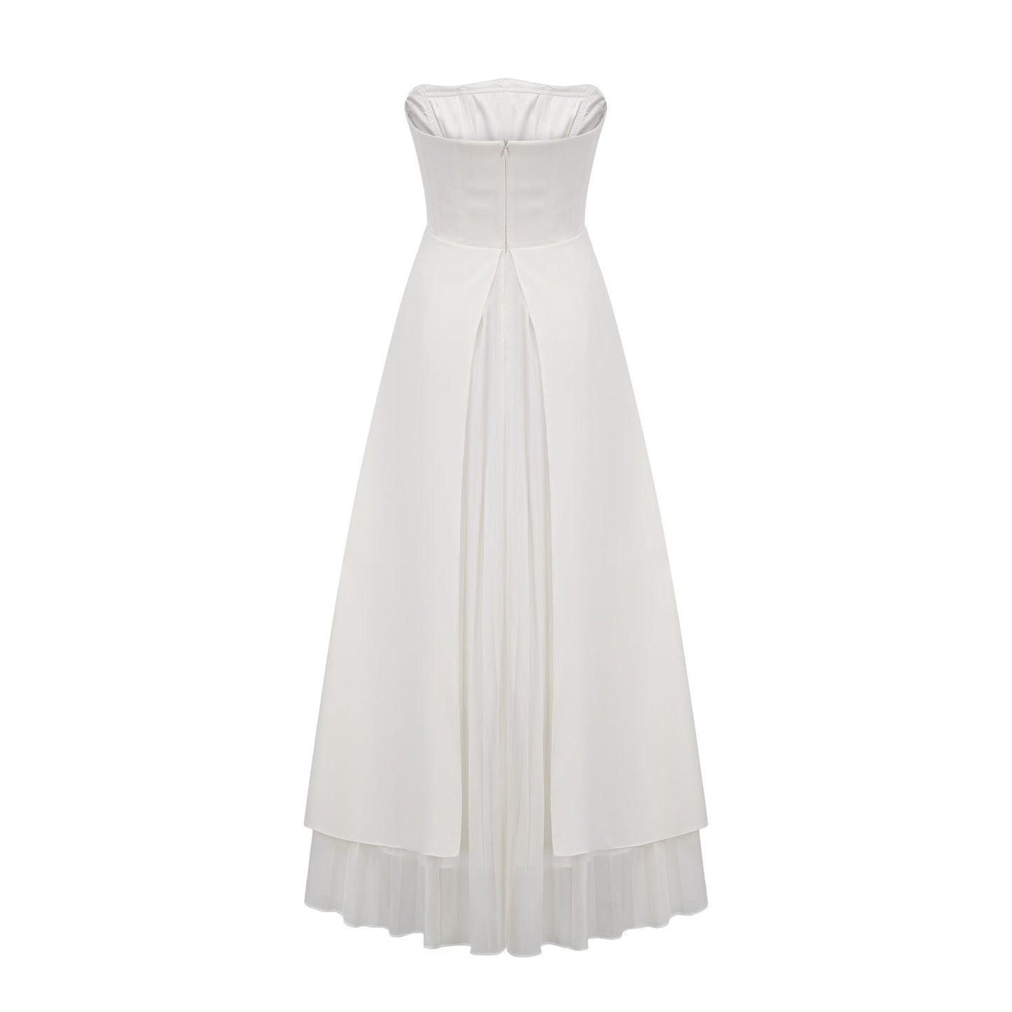A woman wearing a white pleated offshoulder maxi dress with a flowing skirt standing against a plain background