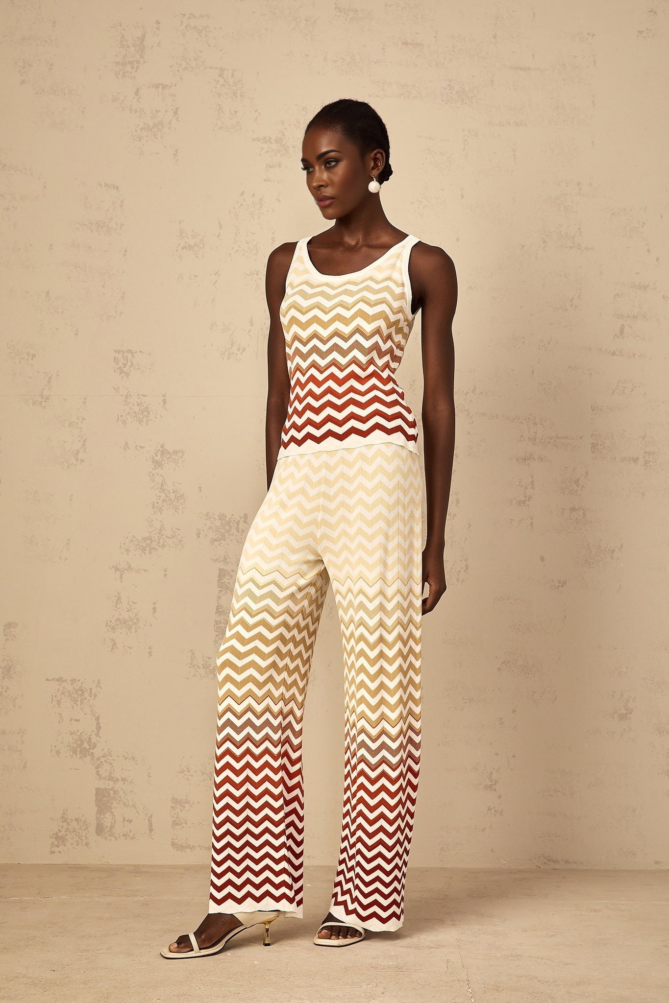 A woman wearing a yellow zigzag knit matching set consisting of a top and bottom loungewear outfit