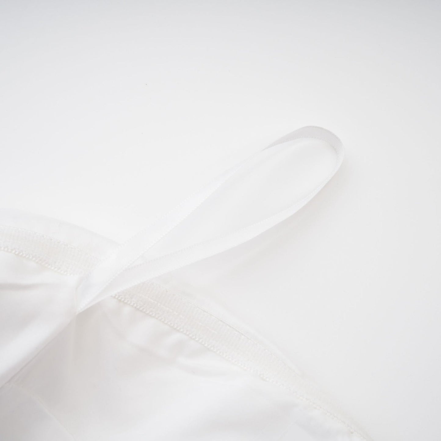 A woman wearing an elegant white off the shoulder dress with a flowing silhouette
