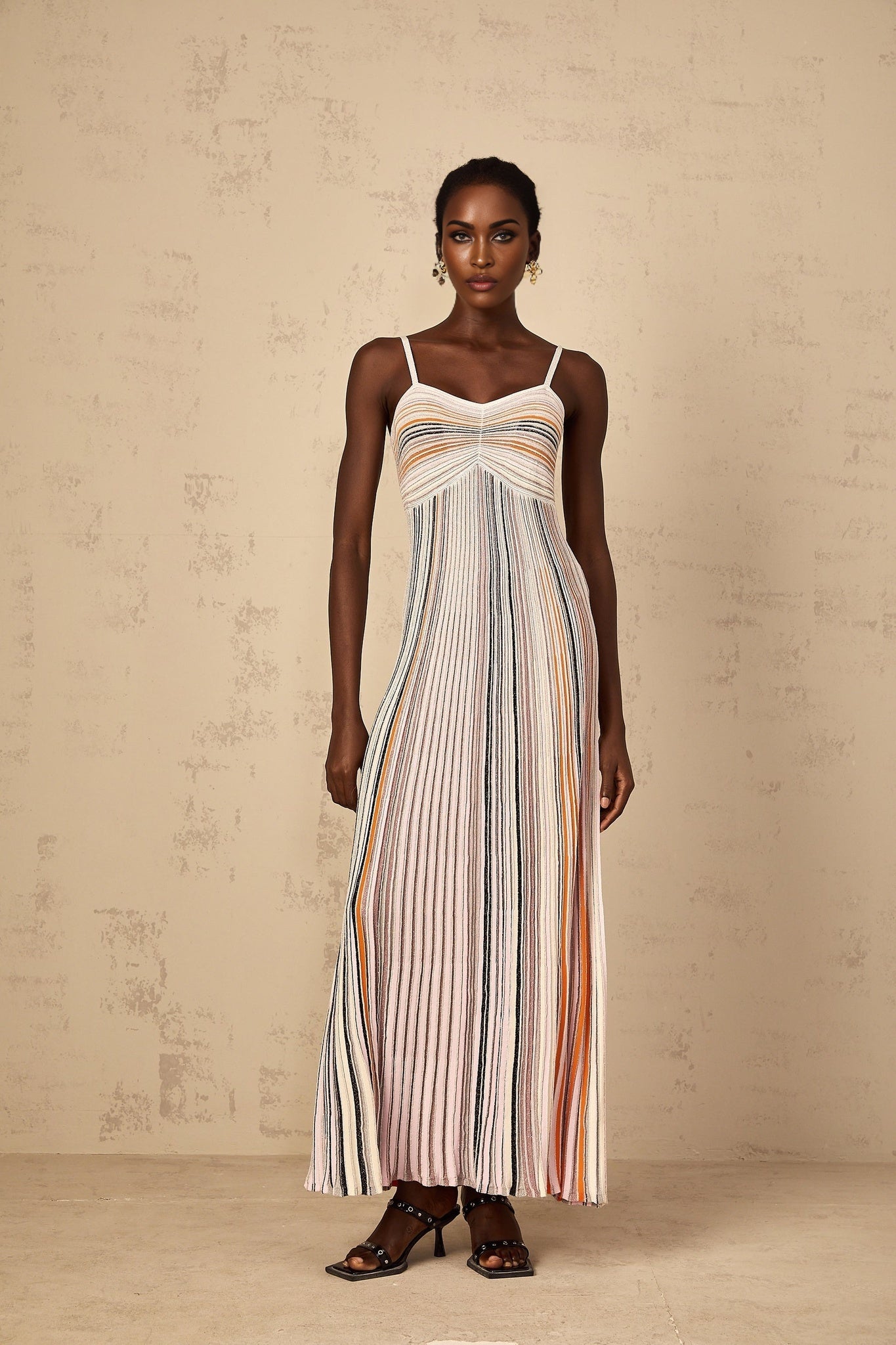 A womens maxi dress with neutral colored sequin stripes on a knit fabric featuring a long length and sleek design