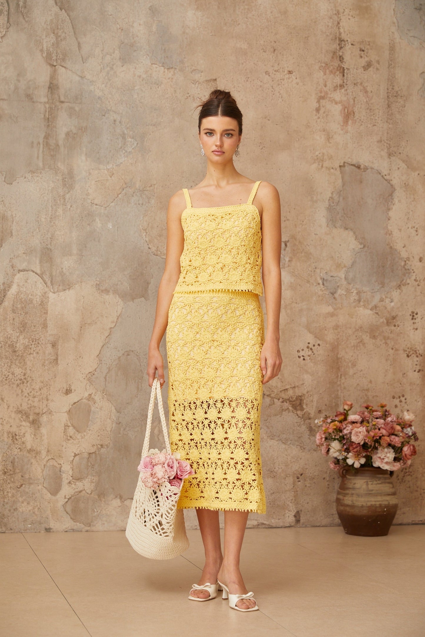 A yellow crochet knit matching set consisting of a top and skirt named Isoline The outfit features intricate crochet patterns throughout both pieces