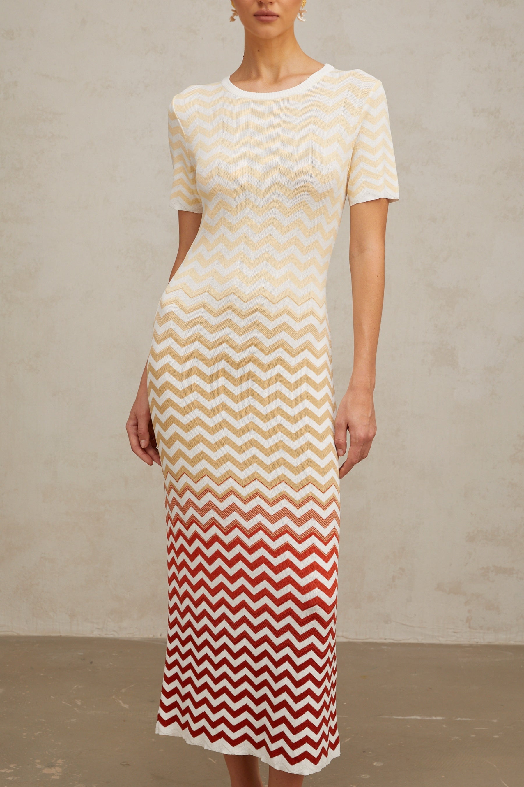 A yellow knit midi dress with a zigzag pattern featuring Isabelle design worn by a model against a plain background