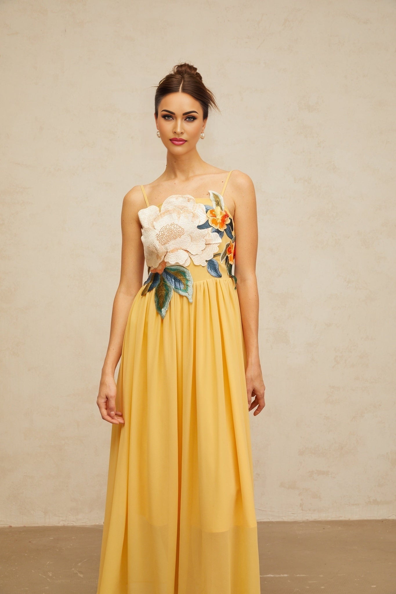 A yellow maxi dress with floral embroidery and shirred detailing called Josette