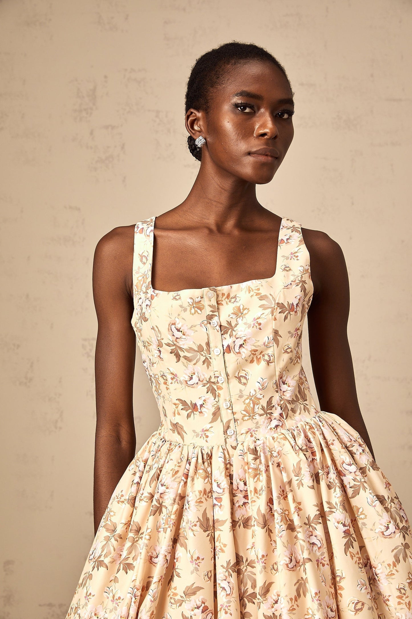 A yellow midi dress with a floral print pattern and button details