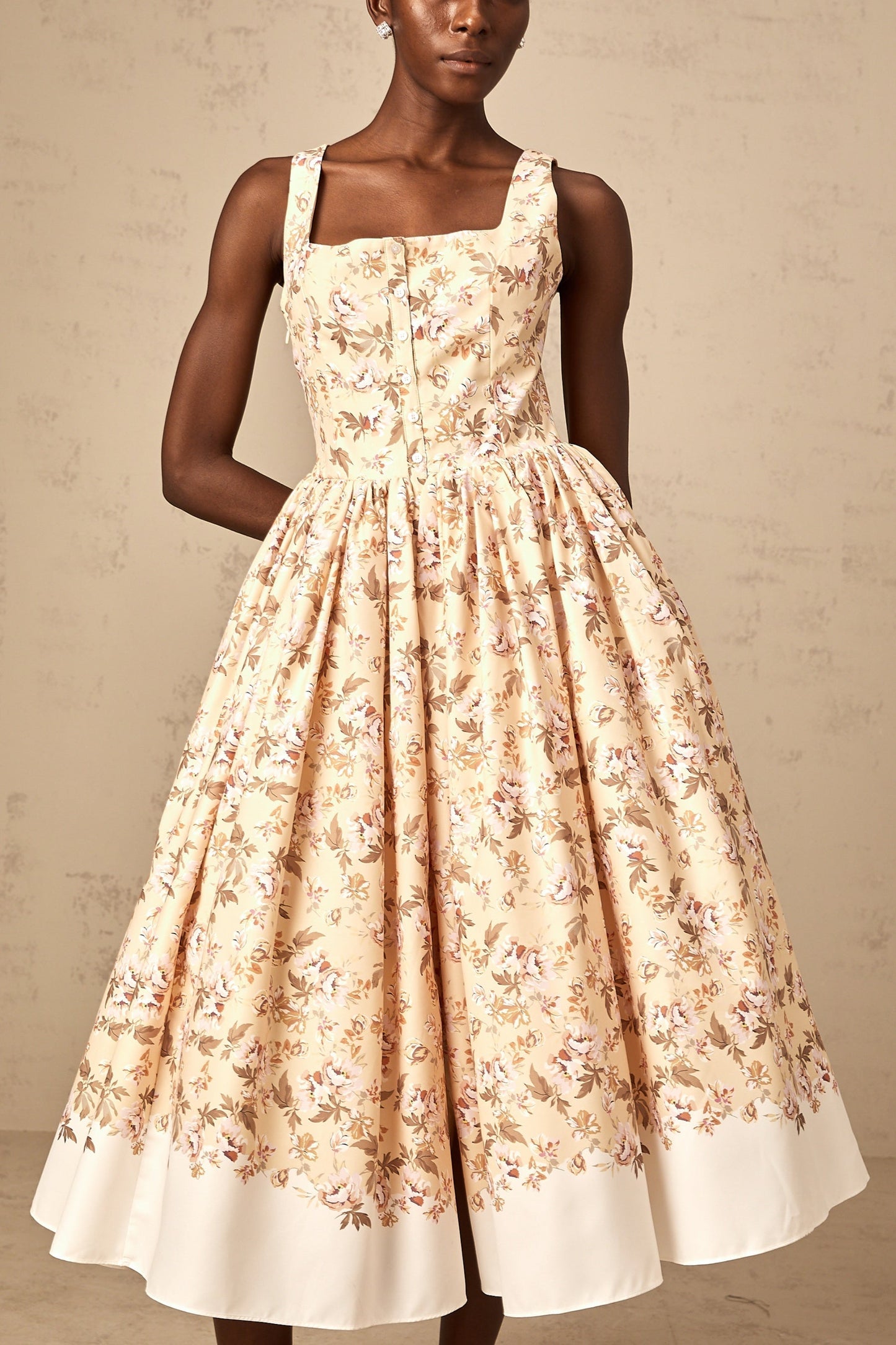 A yellow midi dress with a floral print pattern and button details