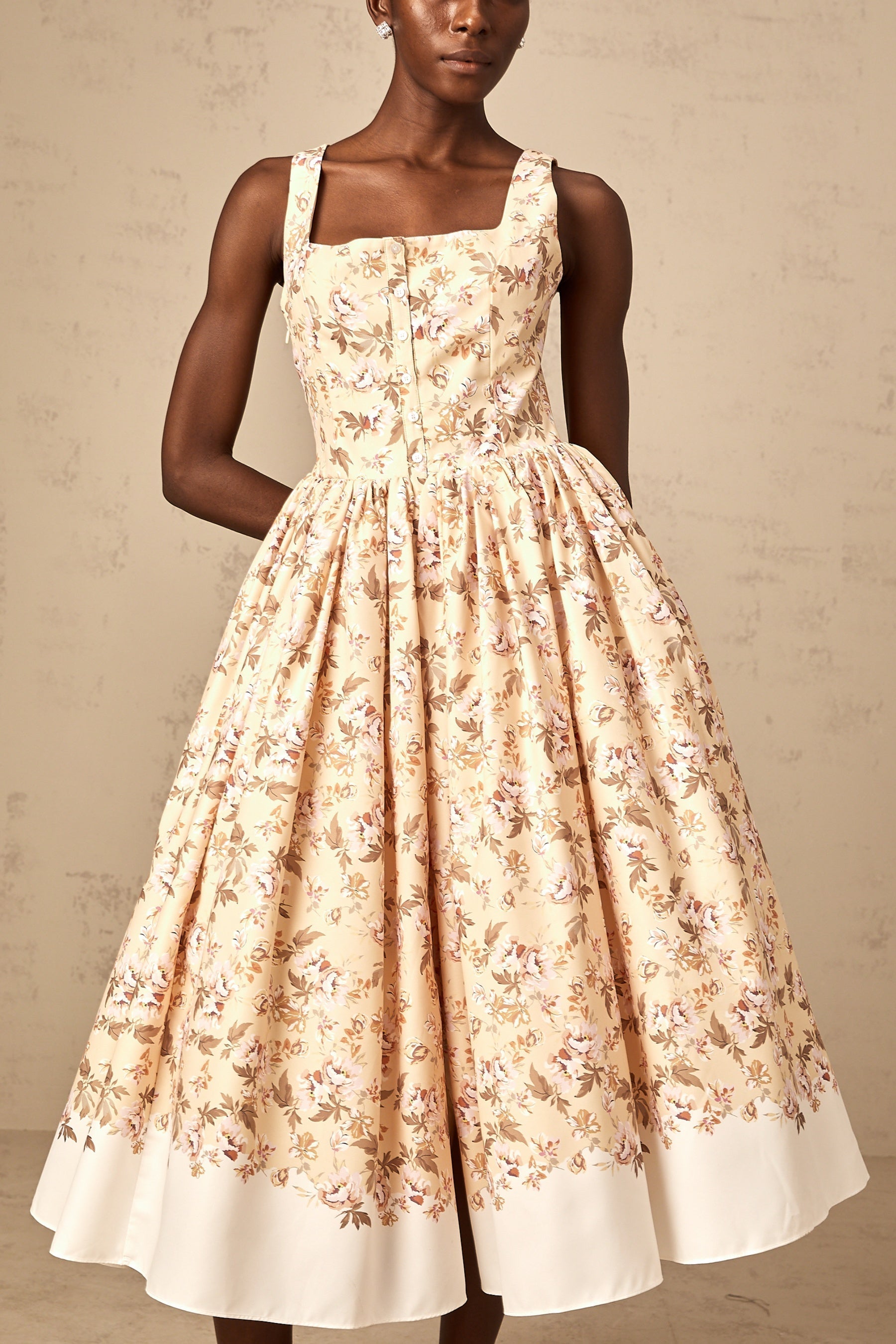 A yellow midi dress with a floral print pattern and button details