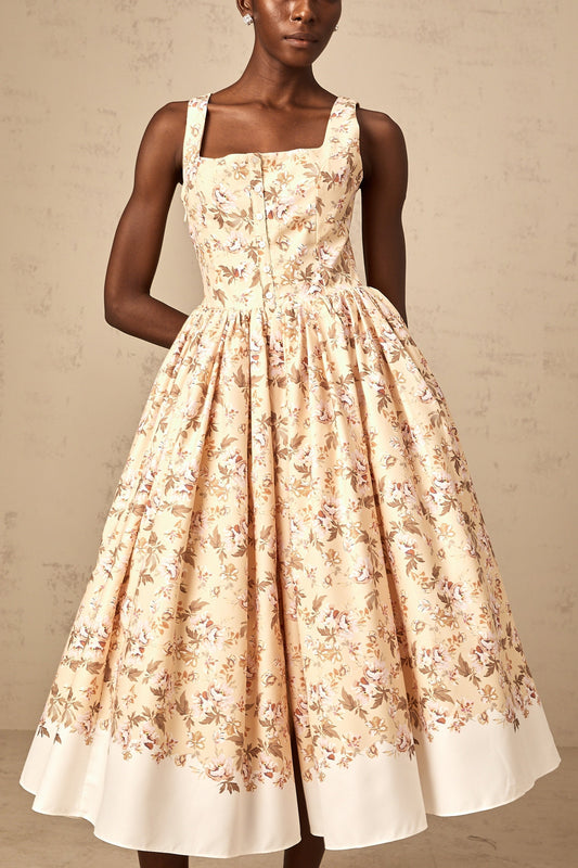 A yellow midi dress with a floral print pattern and button details