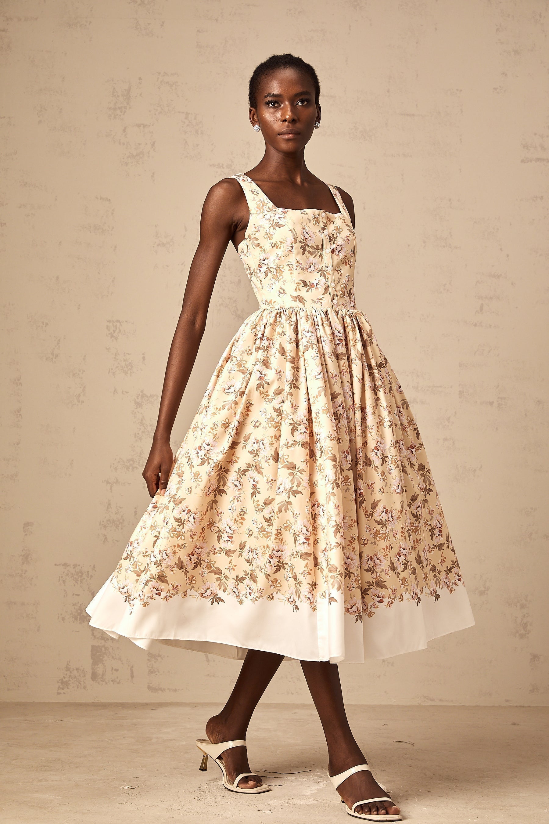 A yellow midi dress with a floral print pattern and button details