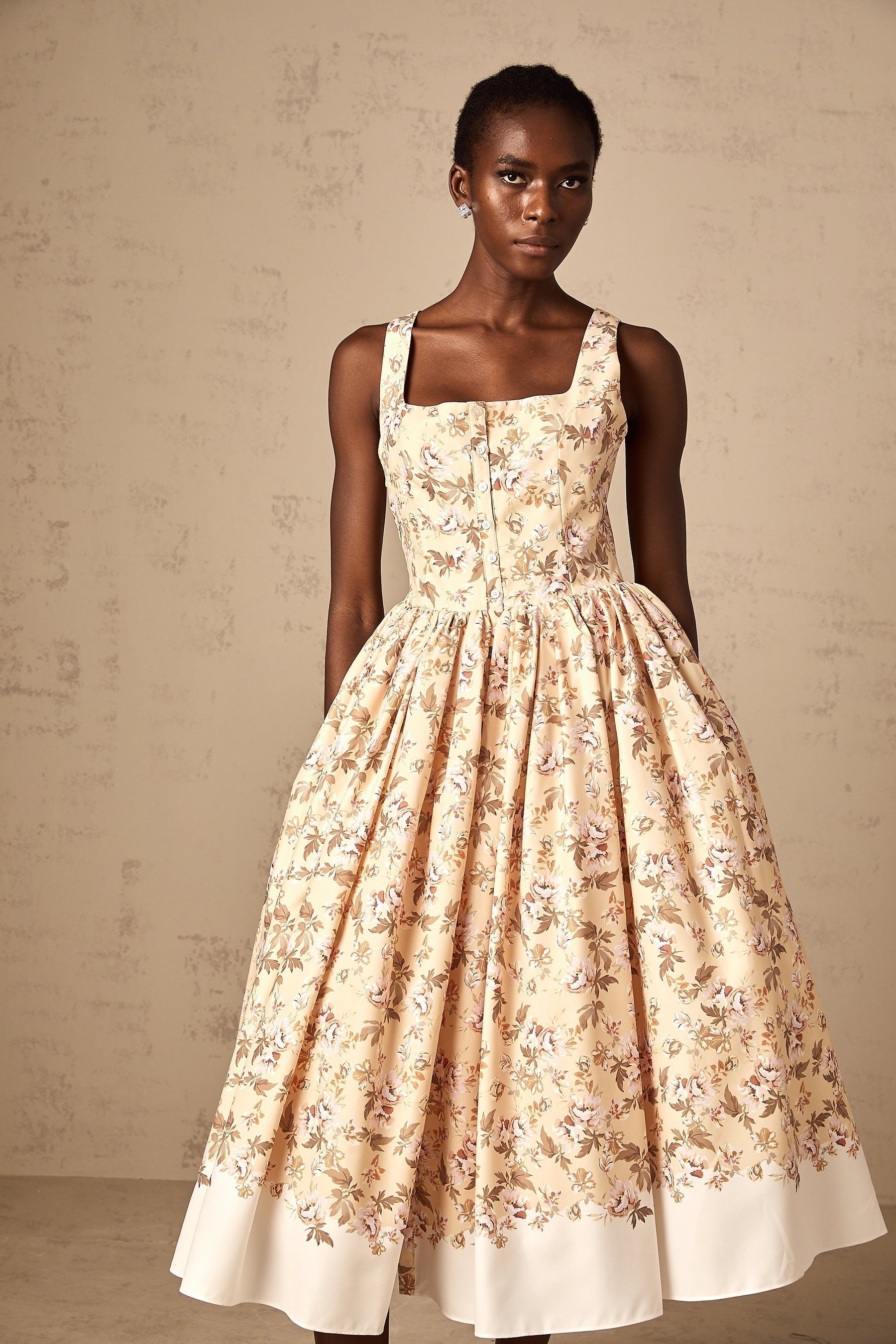 A yellow midi dress with a floral print pattern and buttons down the front