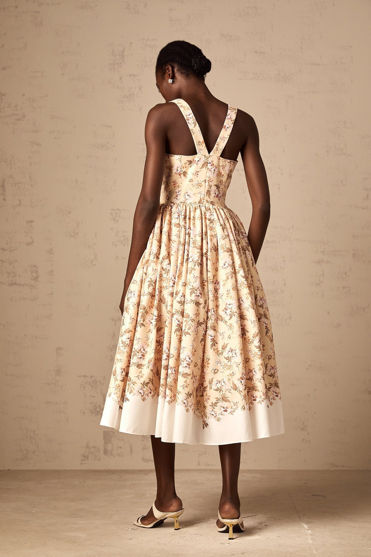 A yellow midi dress with a floral print pattern and buttons down the front