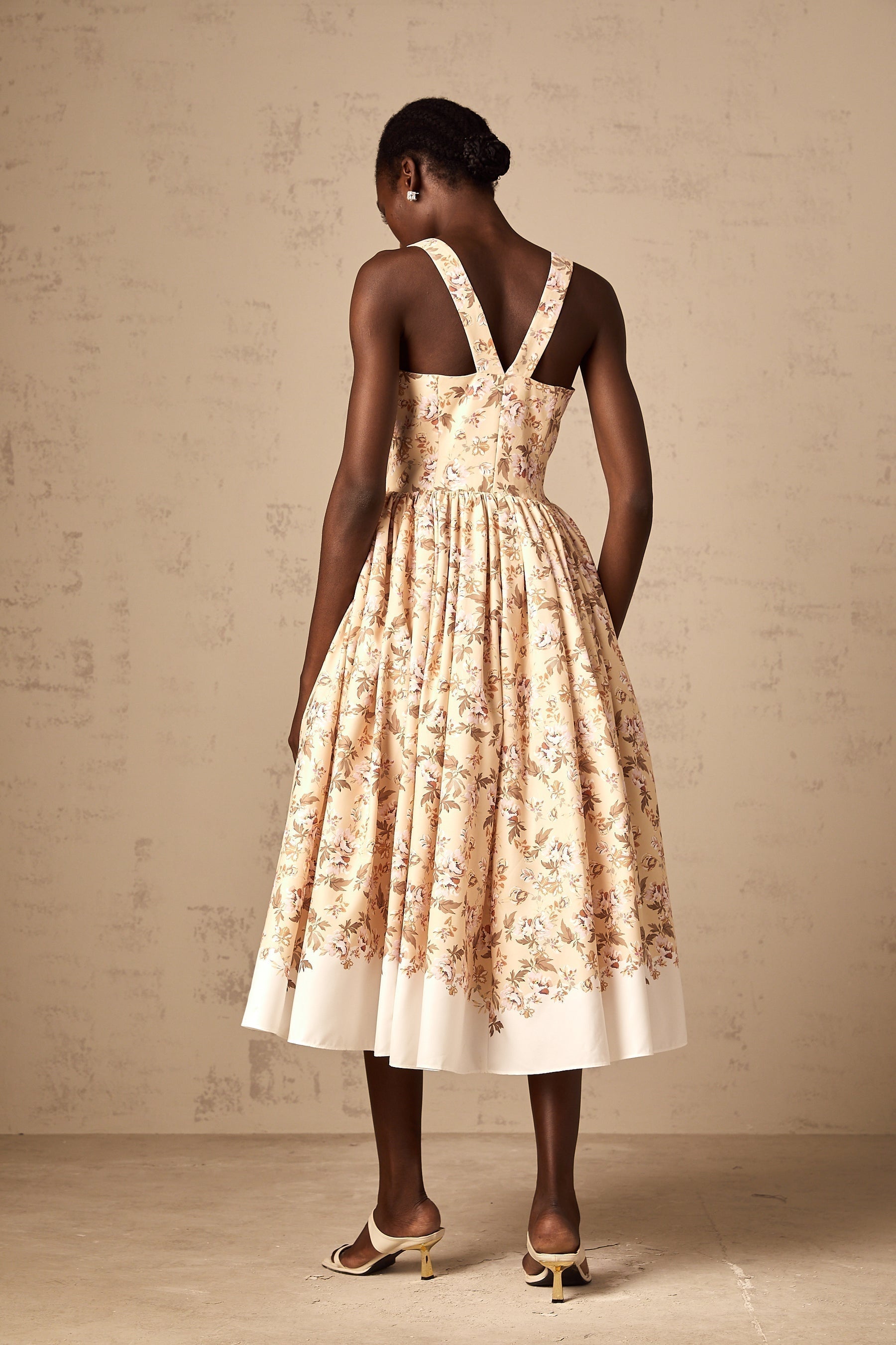 A yellow midi dress with a floral print pattern and buttons down the front