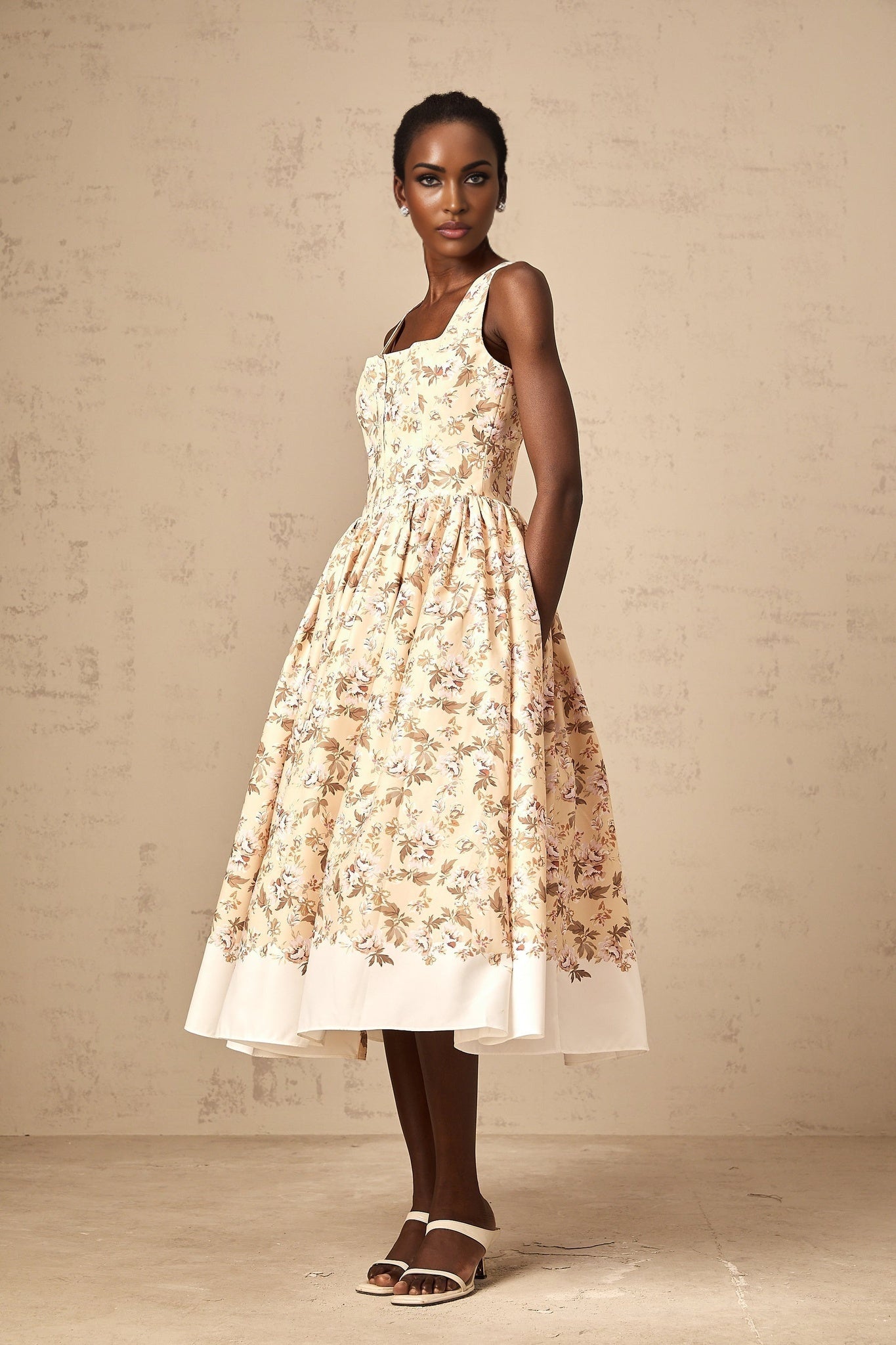 A yellow midi dress with a floral print pattern featuring buttons and a feminine silhouette
