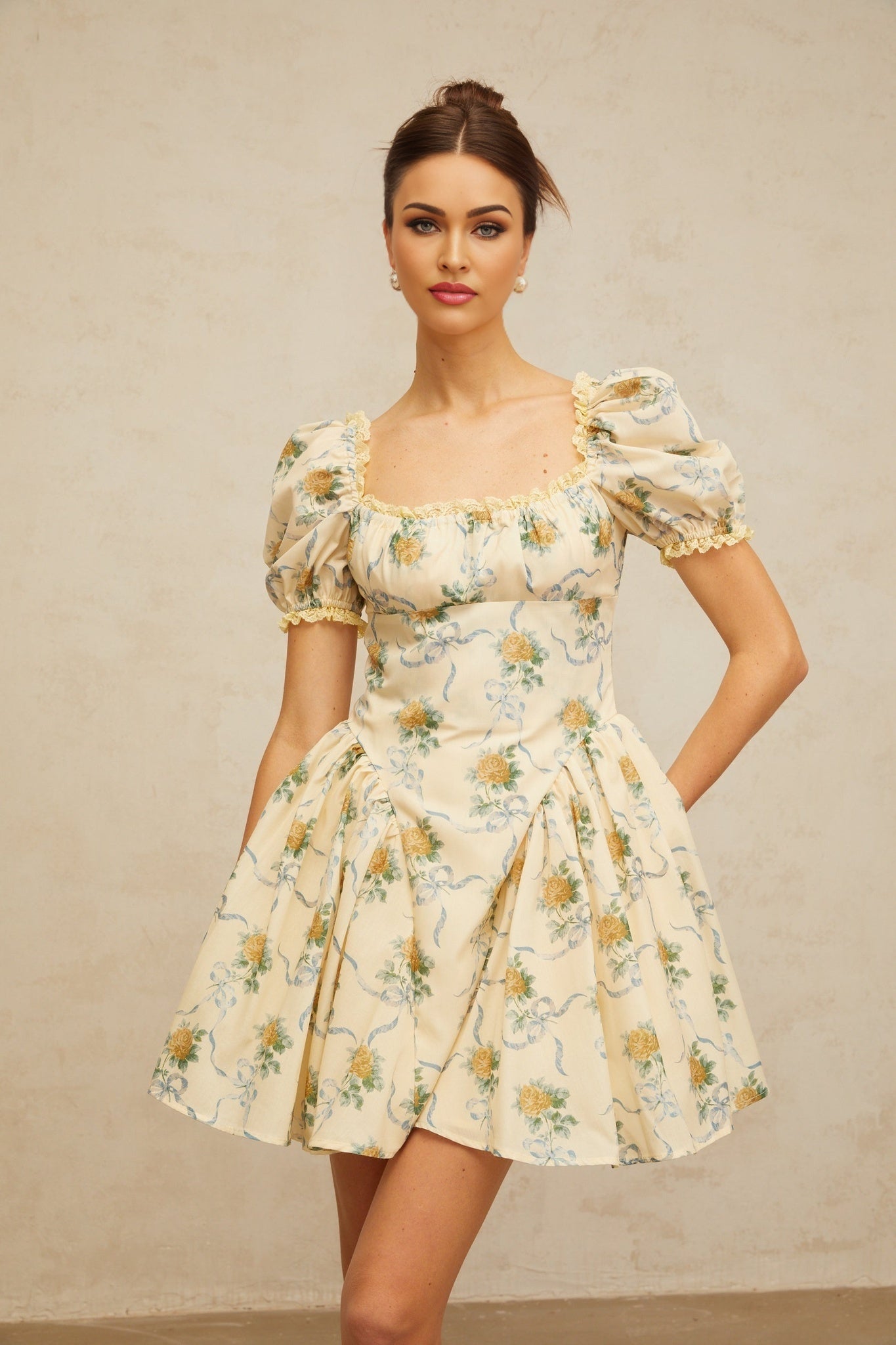 A yellow mini dress with a floral print pattern and shirred detailing named Tiphaine