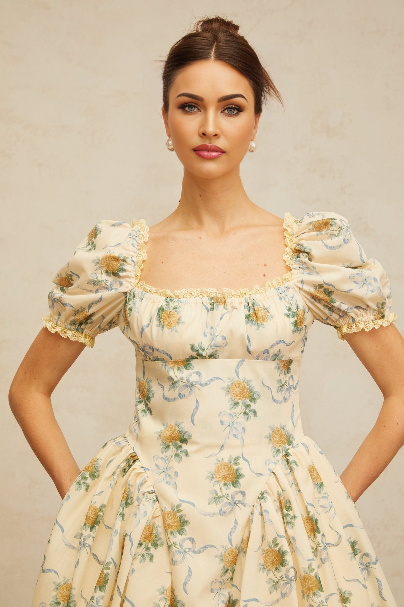 A yellow mini dress with a floral print pattern and shirred detailing named Tiphaine