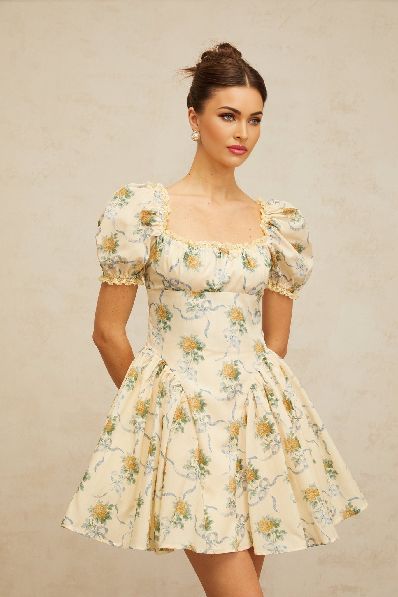 A yellow mini dress with a floral print pattern and shirred detailing named Tiphaine