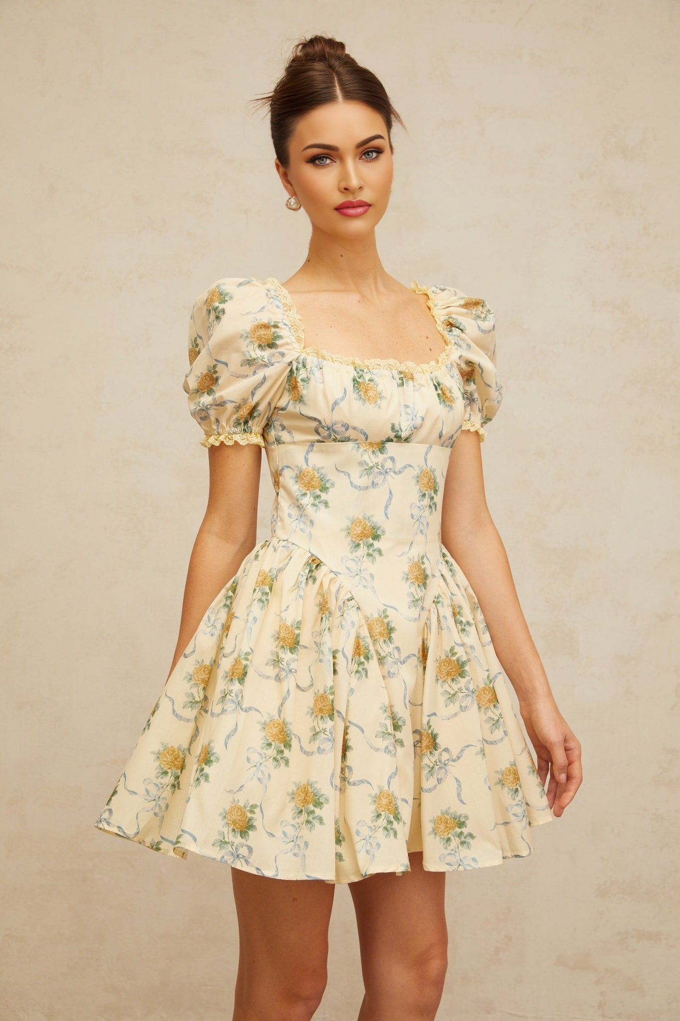 A yellow mini dress with a floral print pattern and shirred detailing named Tiphaine