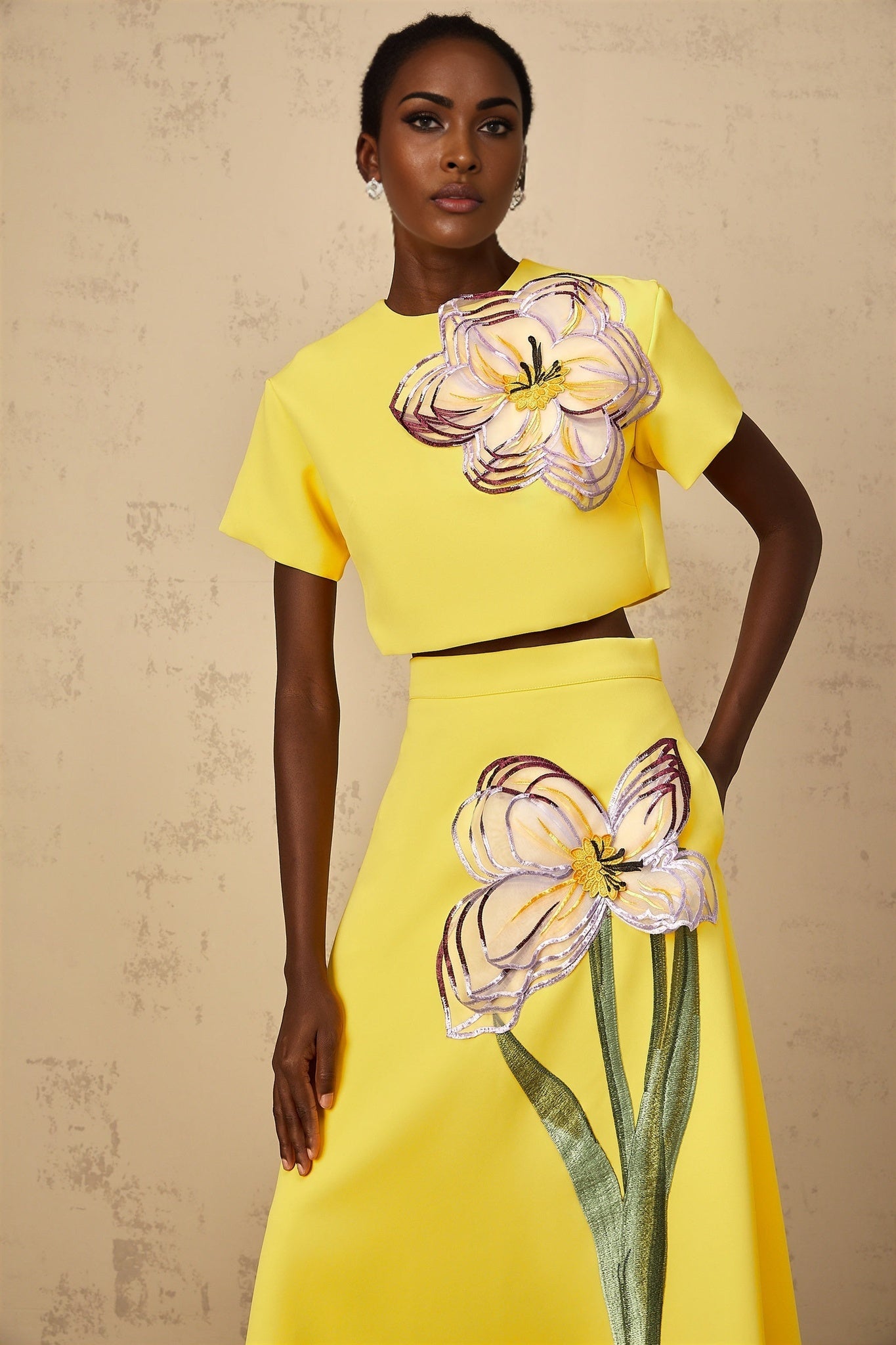 A yellow twopiece outfit featuring a top and bottom with sequin floral embroidery details creating a matching set for women