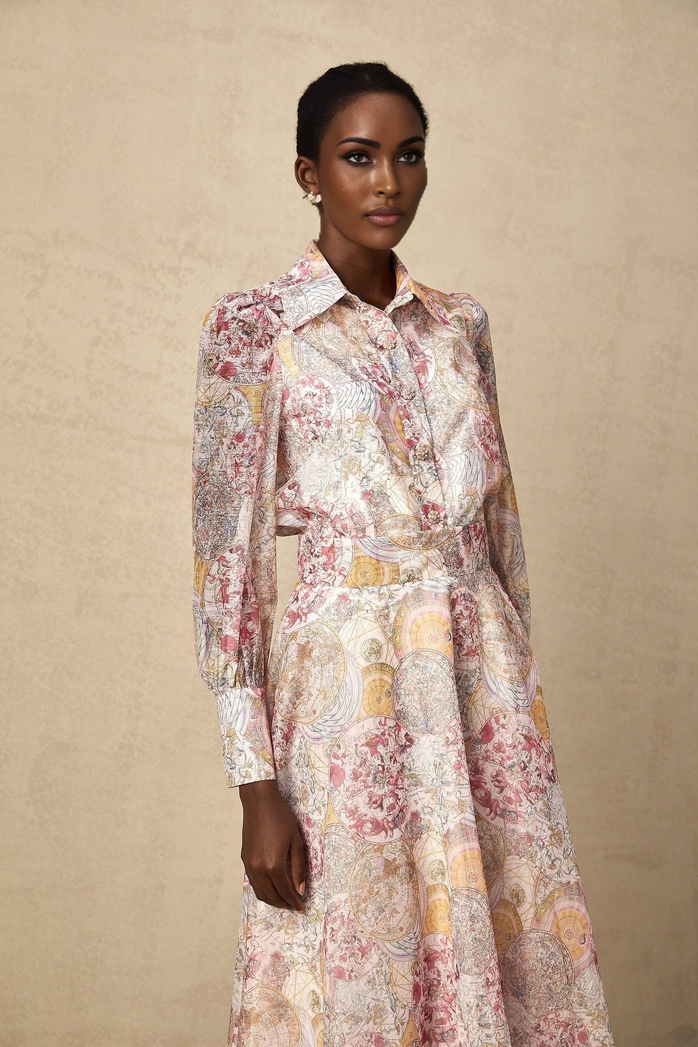 A young girl wearing a cherry pink shirt and matching skirt both featuring a repeating pattern print The set includes a top with short sleeves and a flared skirt creating a coordinated outfit