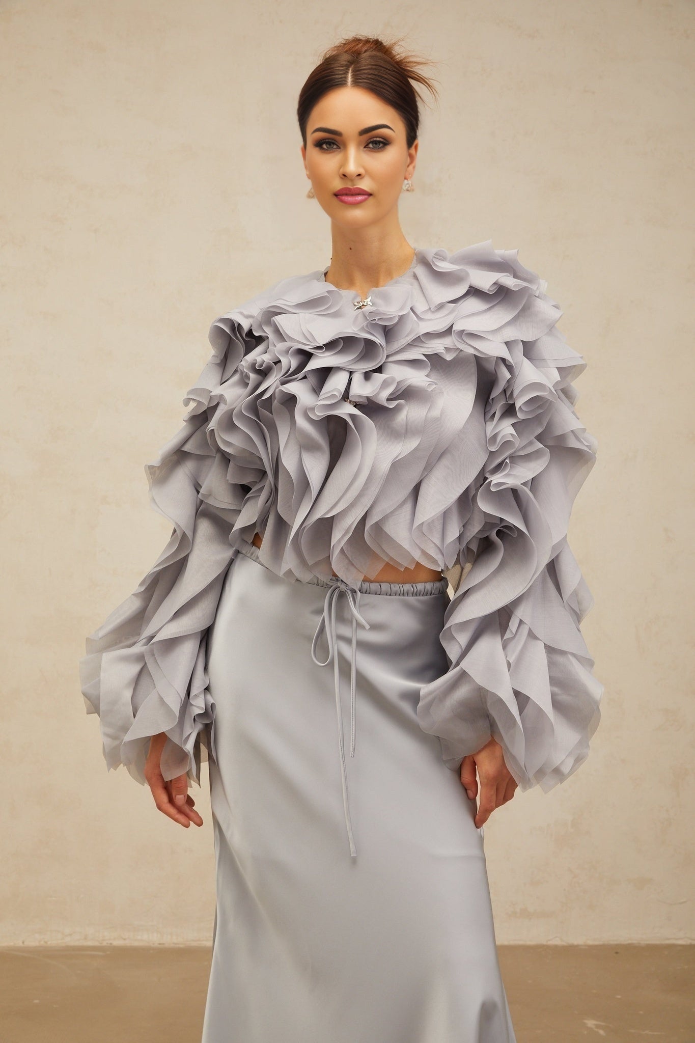 A young girl wearing a light blue blouse with a bow and ruffles paired with a matching skirt featuring a Zelda inspired design