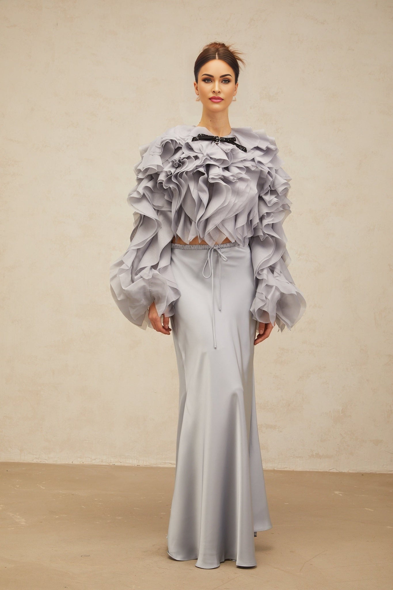 A young girl wearing a light blue blouse with a bowknot and ruffles paired with a matching skirt in Zelda style