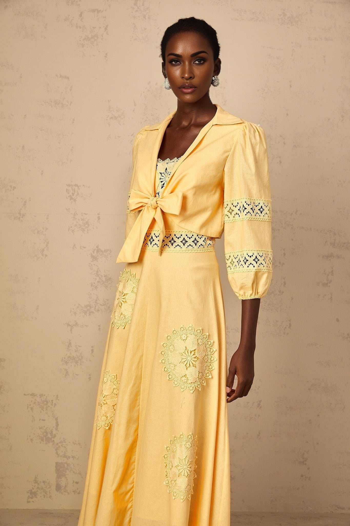 A young girl wearing a yellow blouse and dress set with delicate floral embroidery The blouse features short puff sleeves and the dress has a matching floral pattern The outfit is perfect for spring or summer events