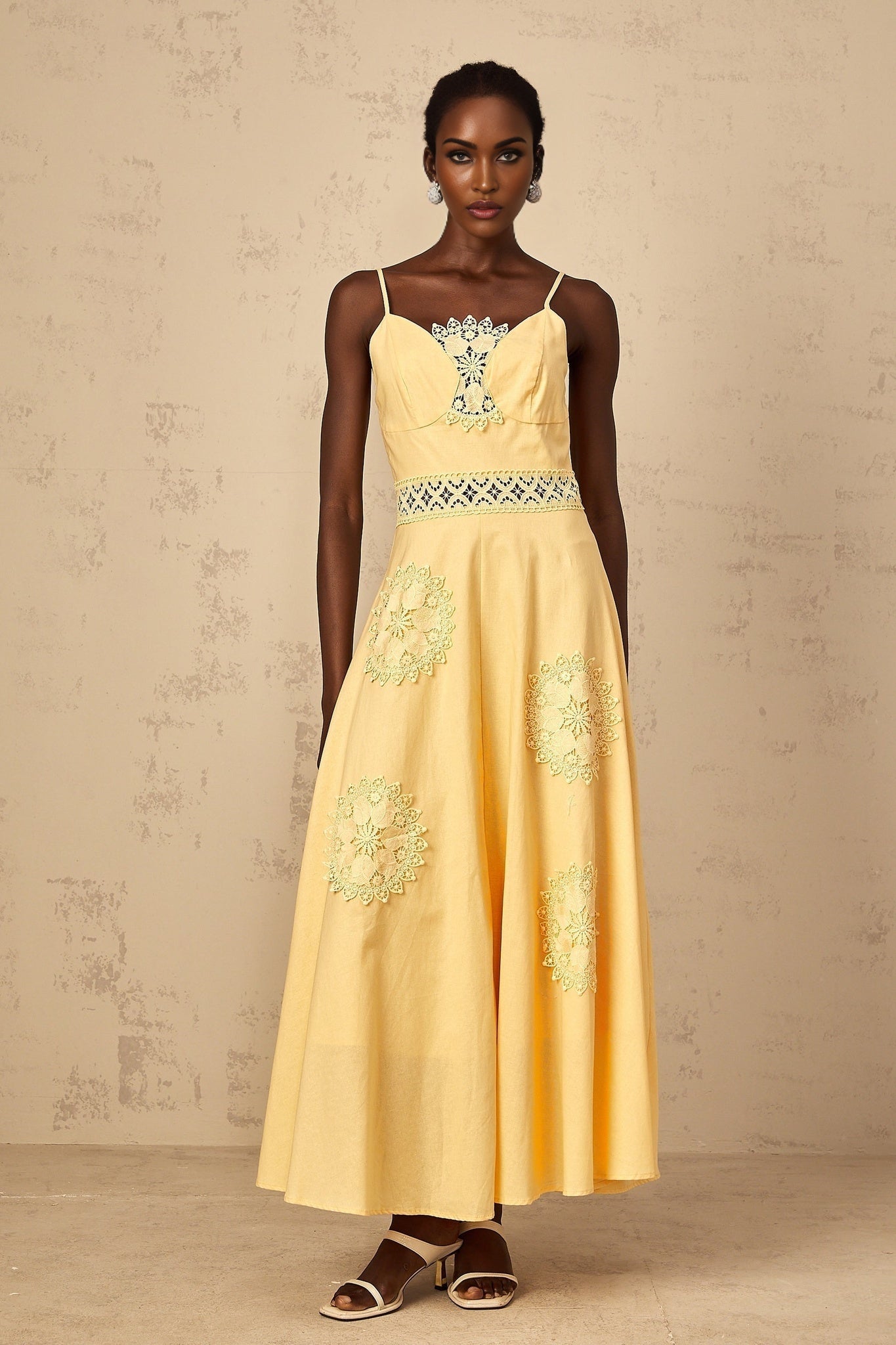 A young girl wearing a yellow blouse and dress set with floral embroidery details The blouse has short puff sleeves and the dress features a matching floral pattern The outfit is bright and cheerful perfect for spring or summer