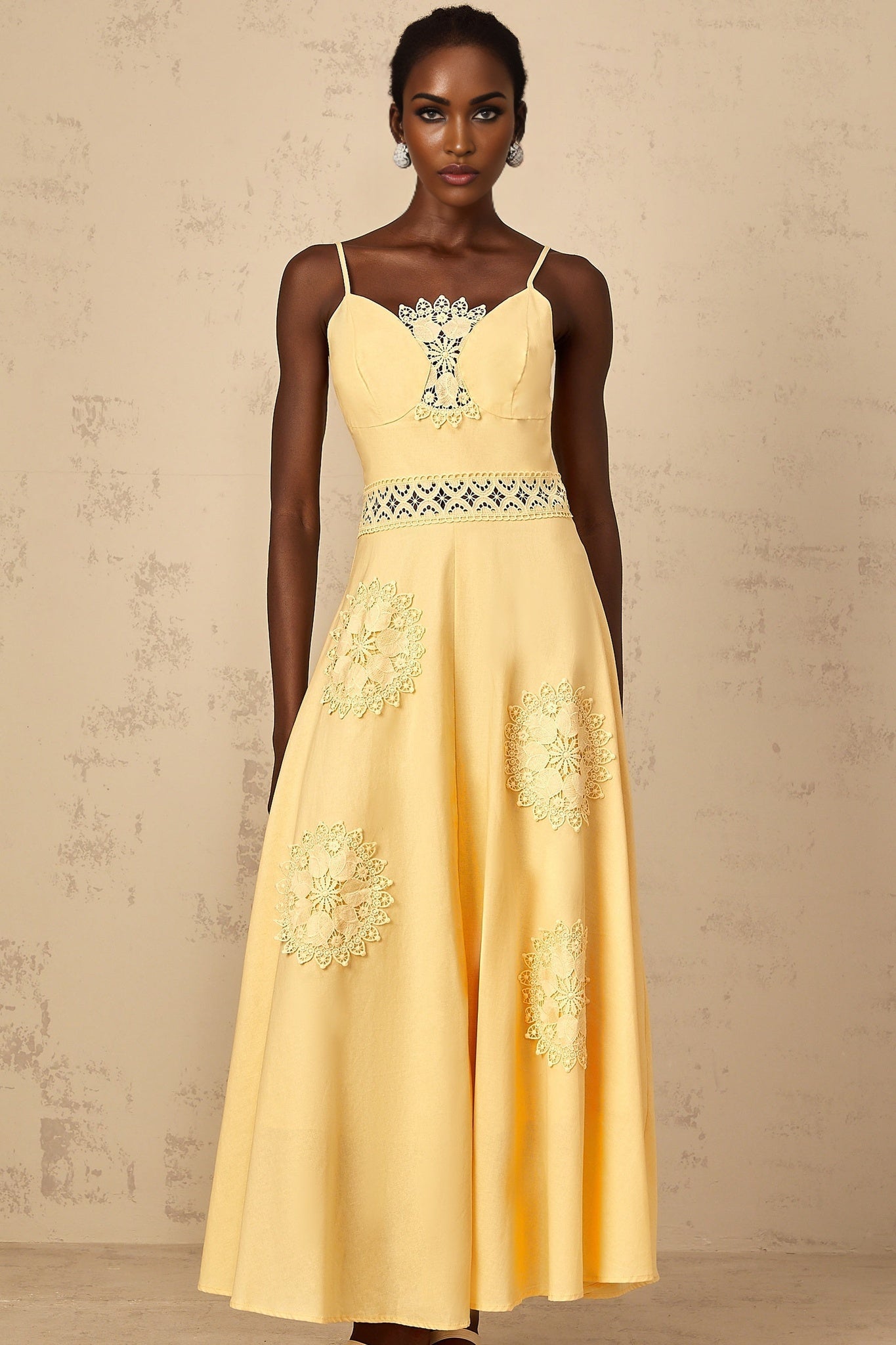A young girl wearing a yellow blouse and dress set with floral embroidery details The blouse has short puff sleeves and the dress features a matching floral pattern The outfit is named Romy and is suitable for children