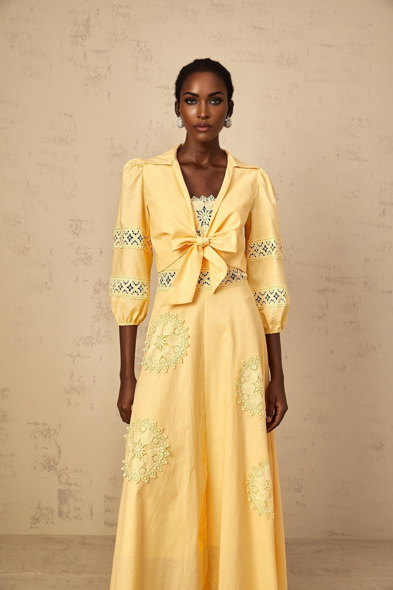 A young girl wearing a yellow floral blouse and matching dress set with embroidered details The outfit features a sunny yellow color with delicate floral embroidery The blouse has short puff sleeves and the dress has a full skirt Perfect for spring or summer occasions