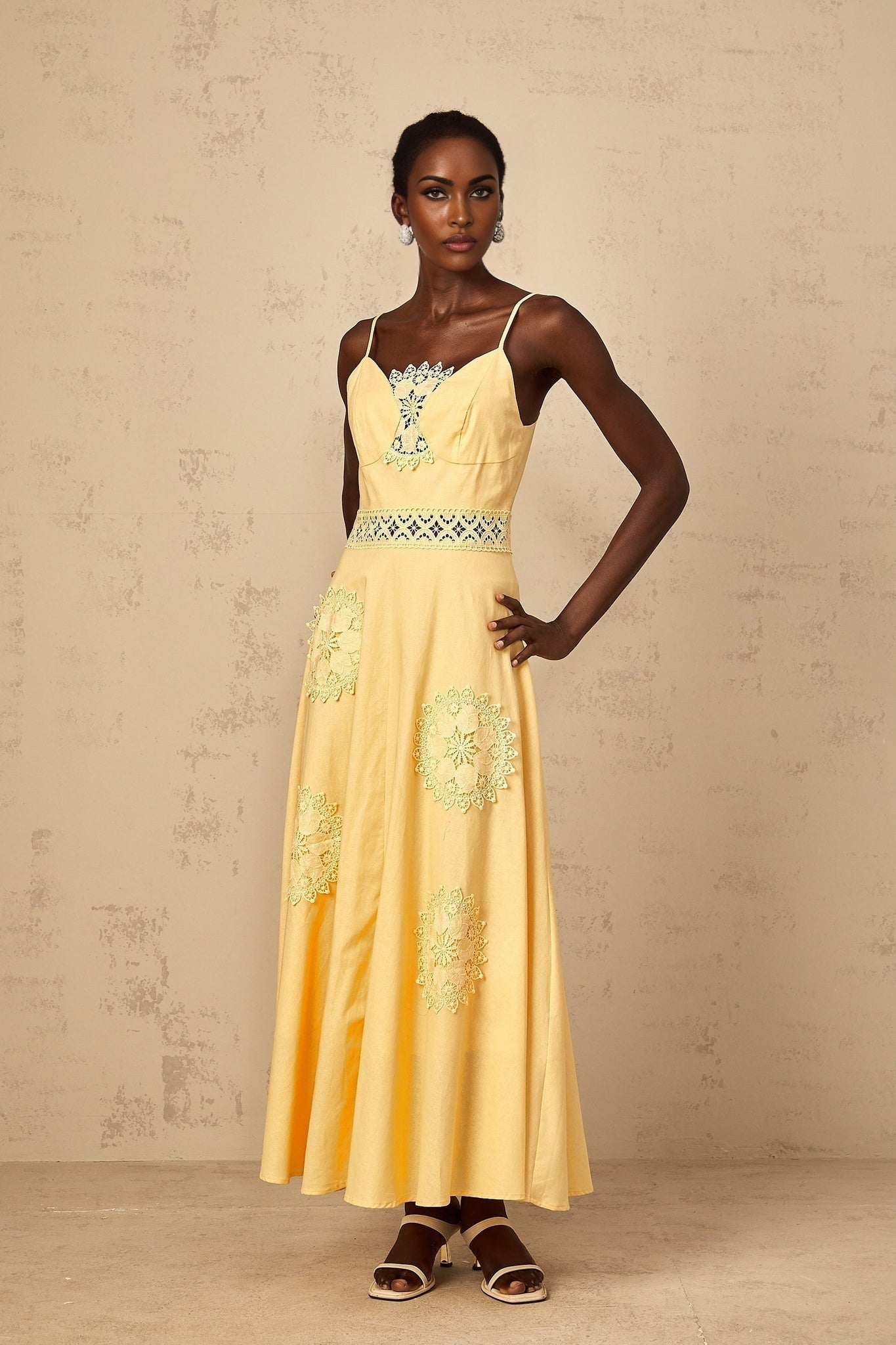 A young girl wearing a yellow floral embroidered blouse paired with a matching dress set featuring delicate flower patterns