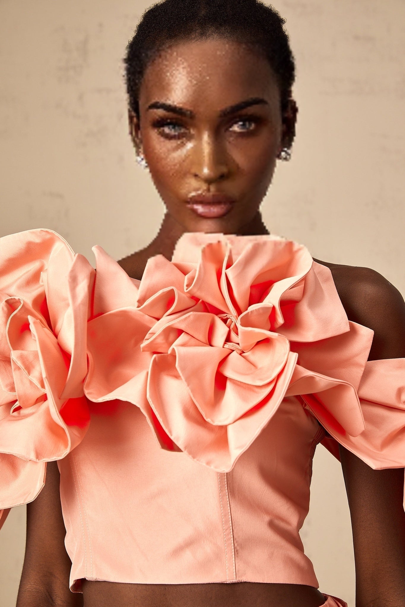 A young woman wearing a pink matching set featuring a top and skirt with floral applique details The outfit has a feminine and summery appearance