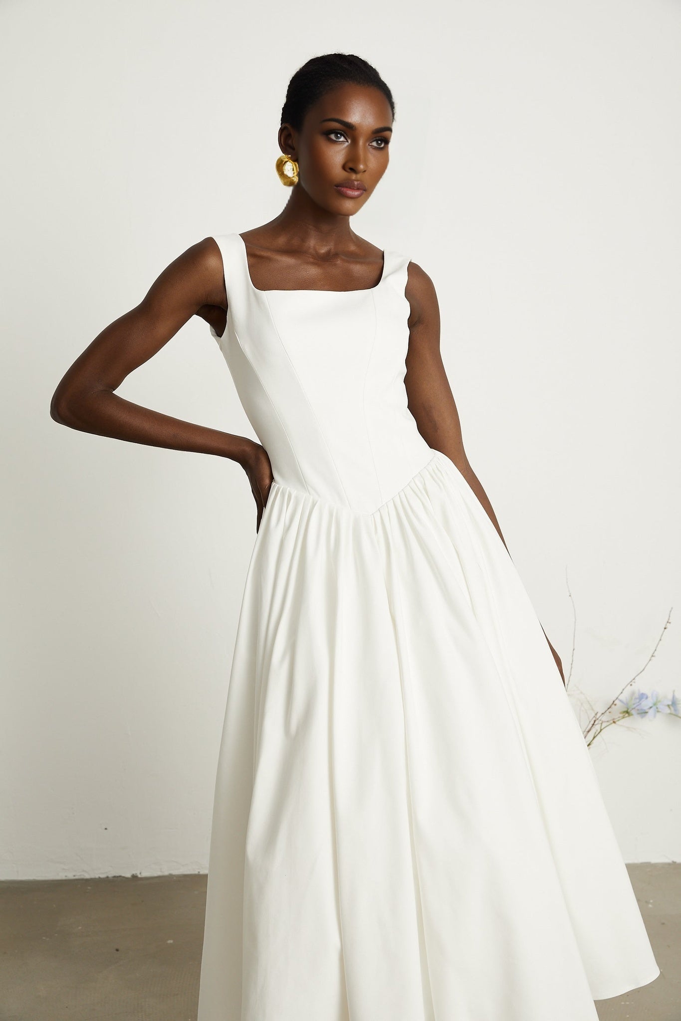 Alt text White pleated corset dress named Sadie with a fitted bodice and flared skirt