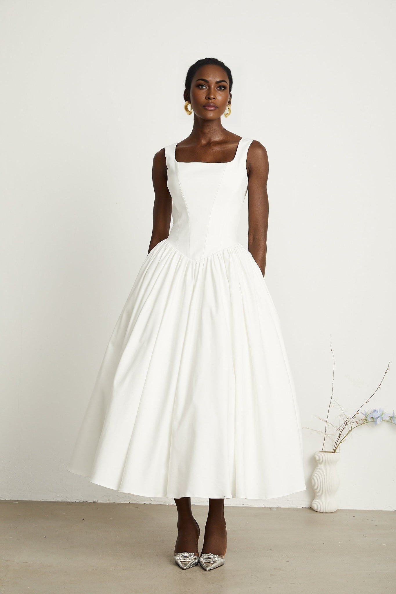Alt text White pleated corset dress named Sadie with a fitted bodice and flared skirt