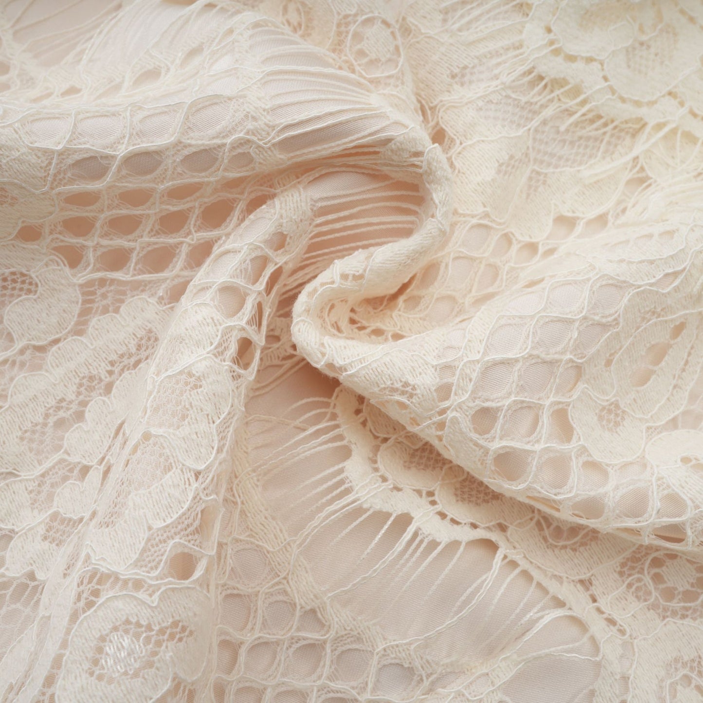 An offwhite blouse with floral lace detailing and a bow accent named Anaelle