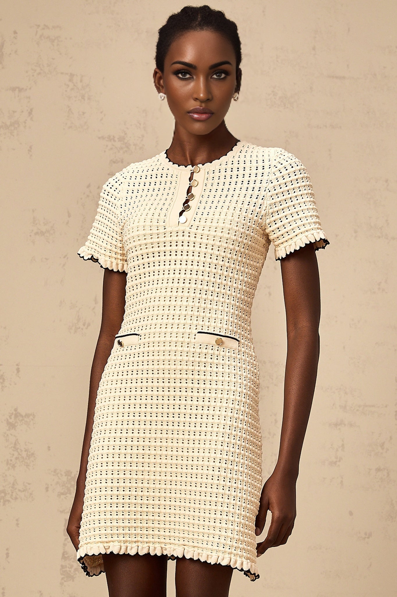 Beige knit mini dress with ruffled details and pointelle pattern