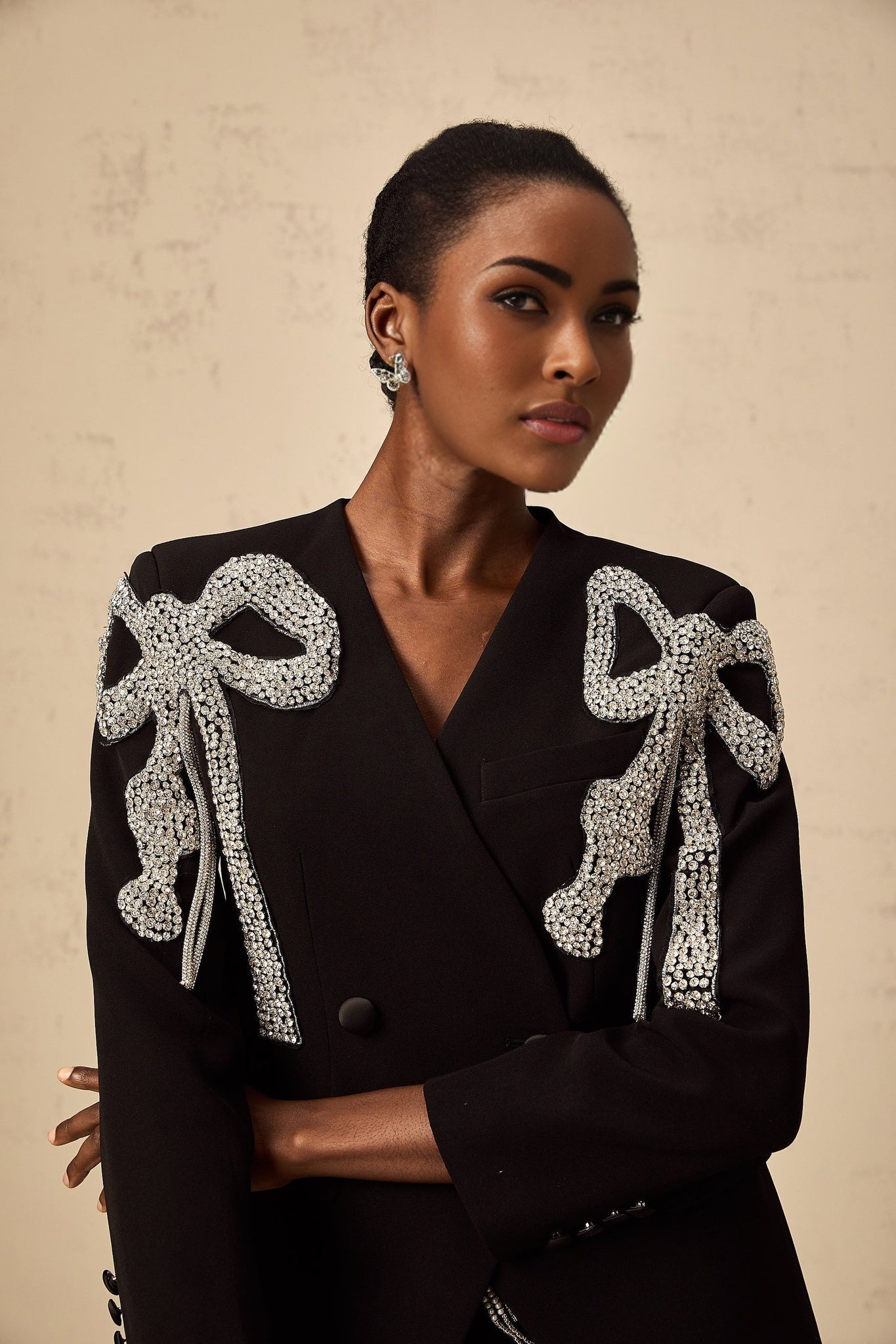 Black blazer with bow motif embellishment on the front