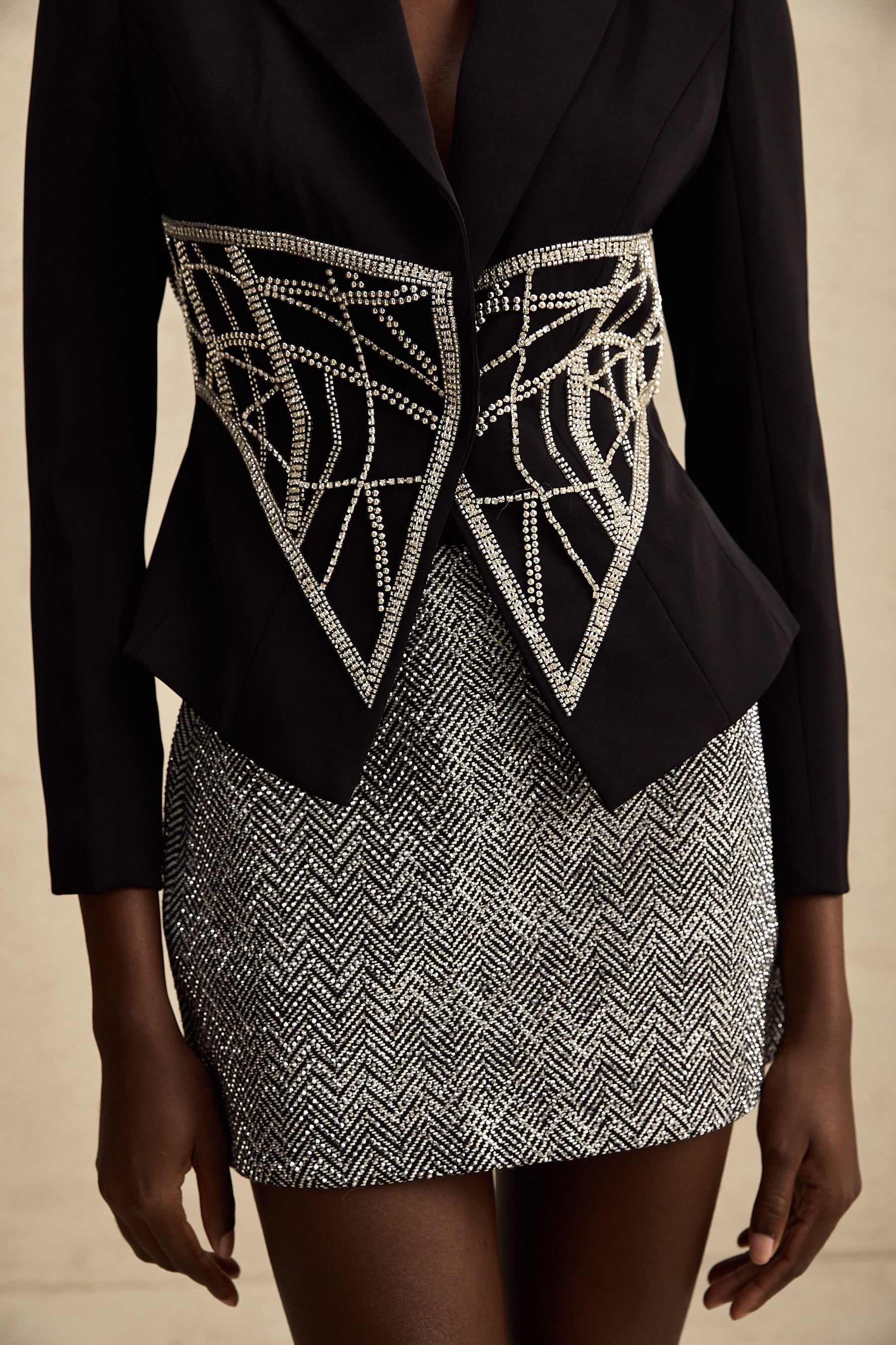 Black fitted jacket with embellished details and cinched waist design by Genevieve