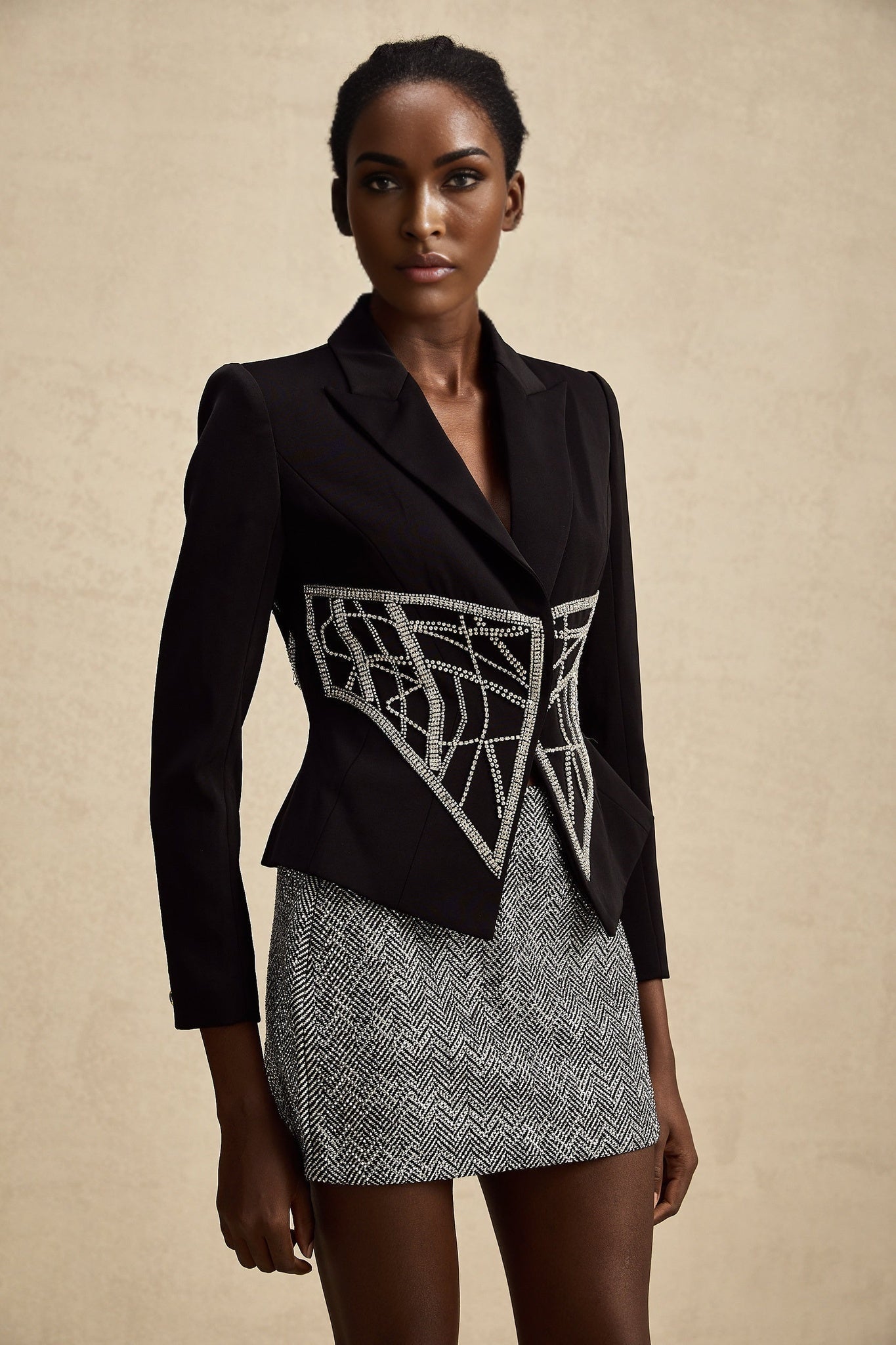 Black fitted jacket with embellished details and cinched waist design
