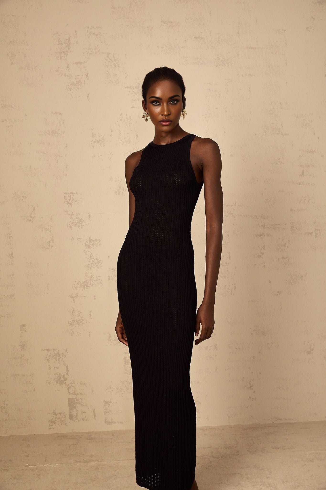 Black fitted ribbed knit maxi dress with long sleeves and floor length skirt