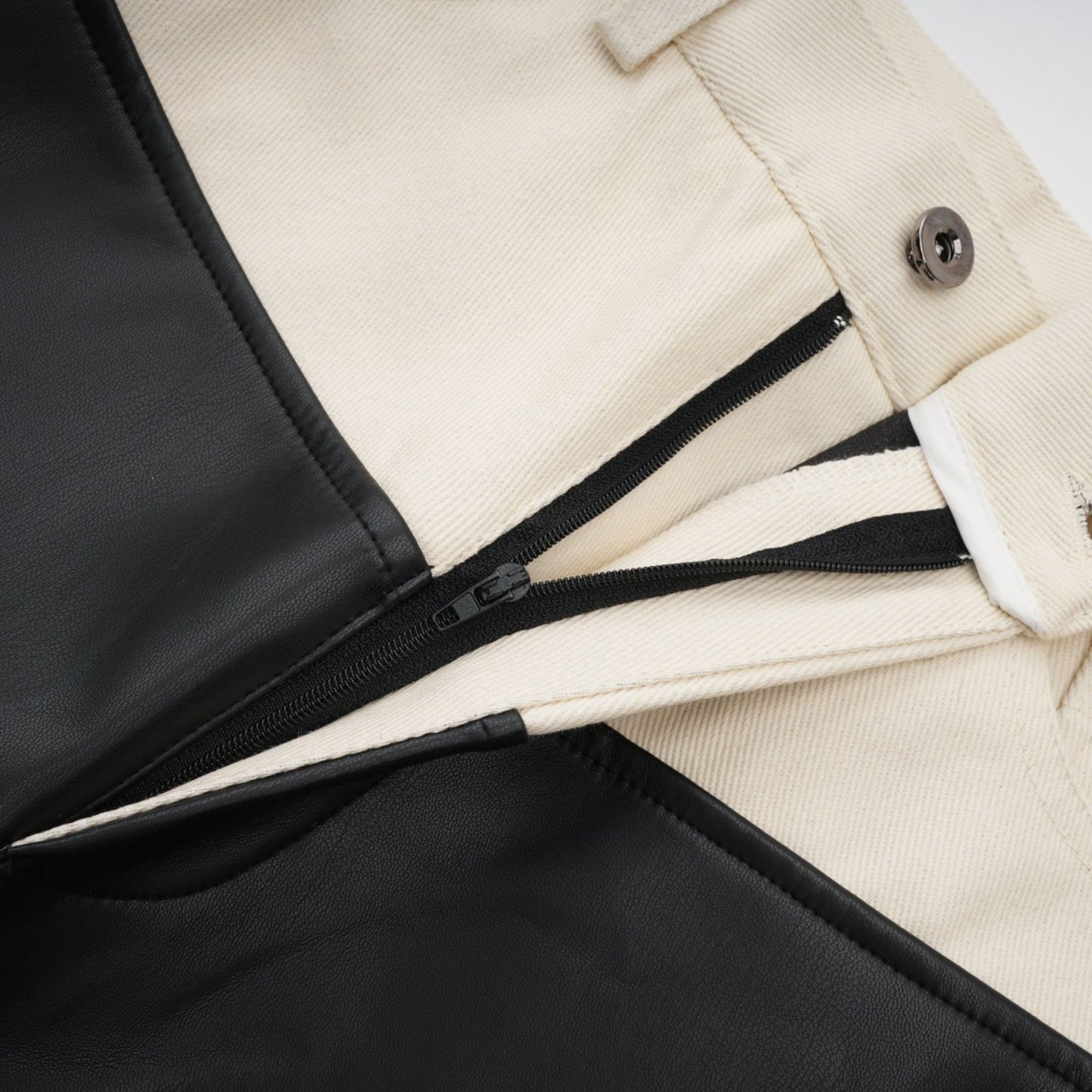 Black leather trousers with contrasting white side panels and waistband