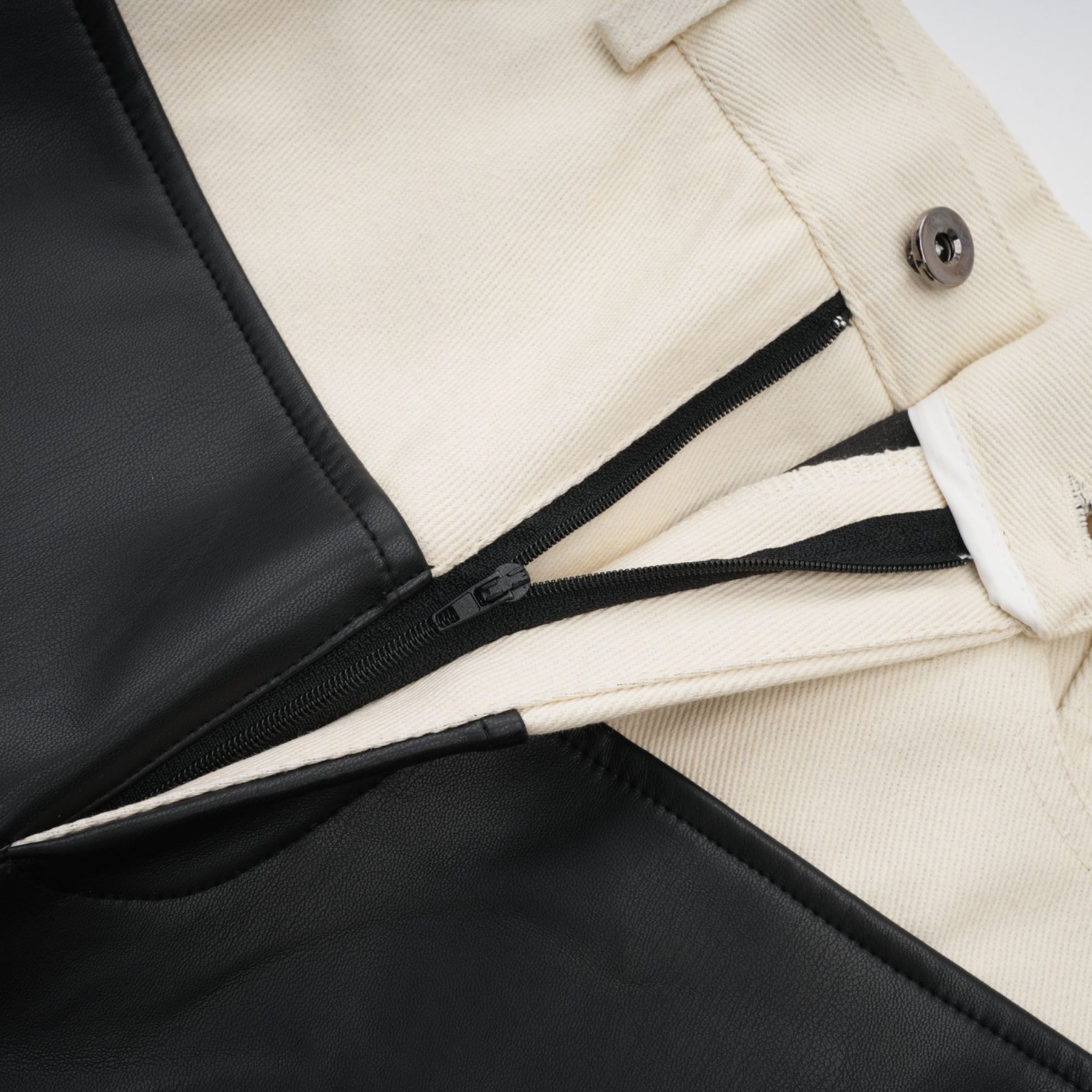 Black leather trousers with contrasting white side panels and waistband