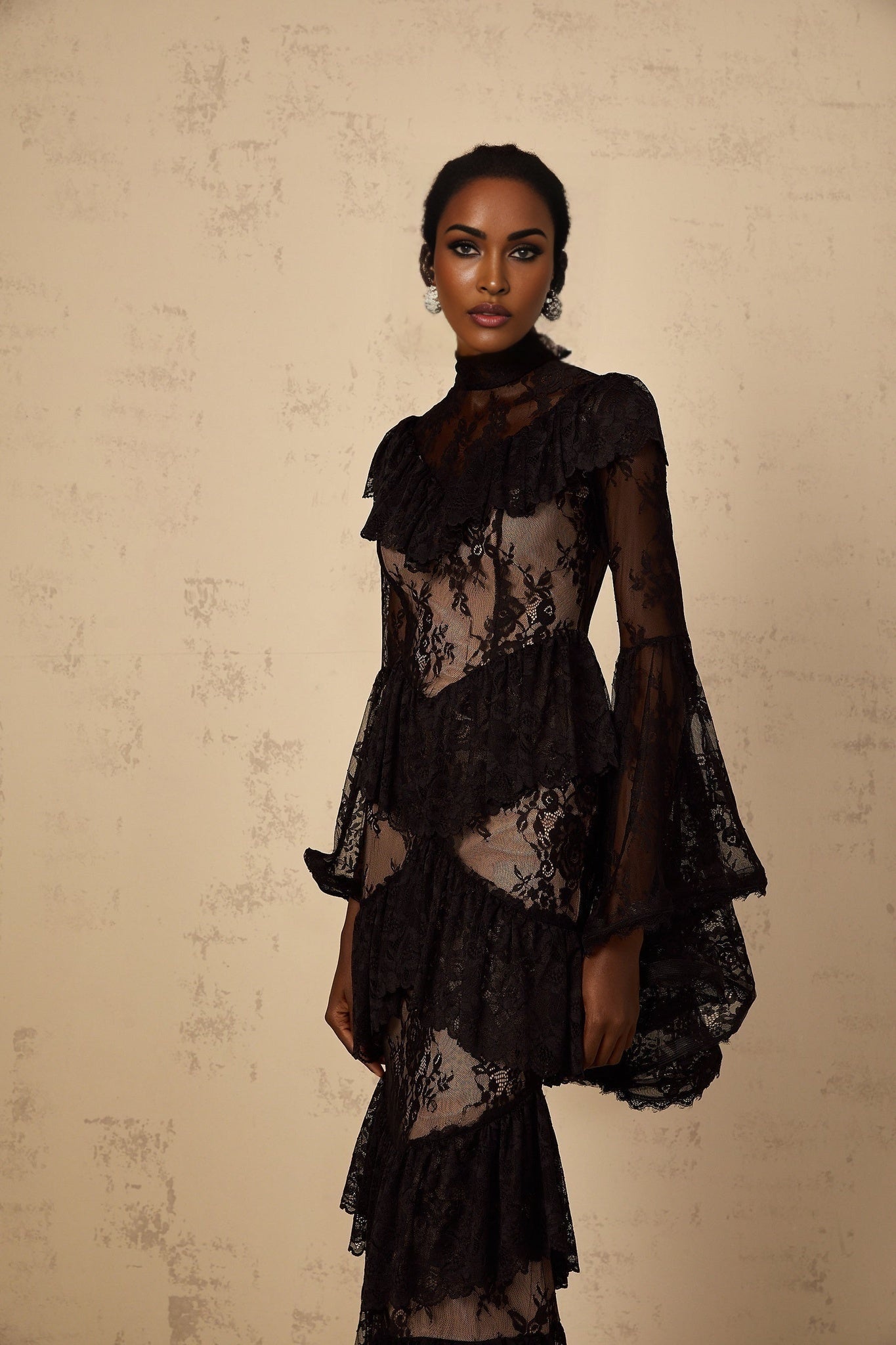 Black maxi dress with floral lace pattern and ruffled details featuring long sleeves and a floor length skirt