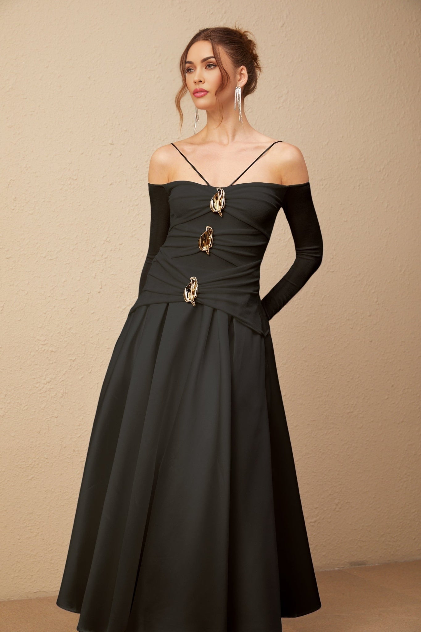 Black offshoulder maxi dress with panels worn by model standing against white background