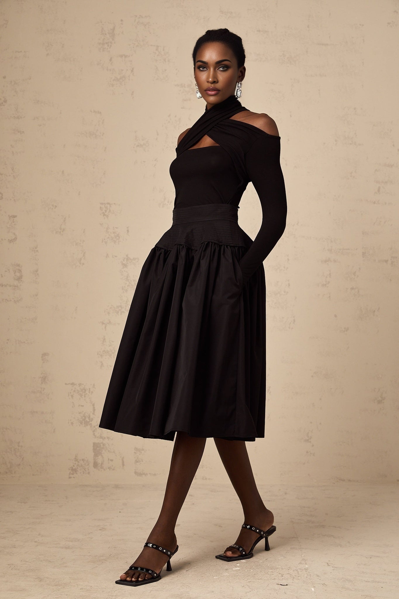 Black pleated midi skirt with flared silhouette named Pauline