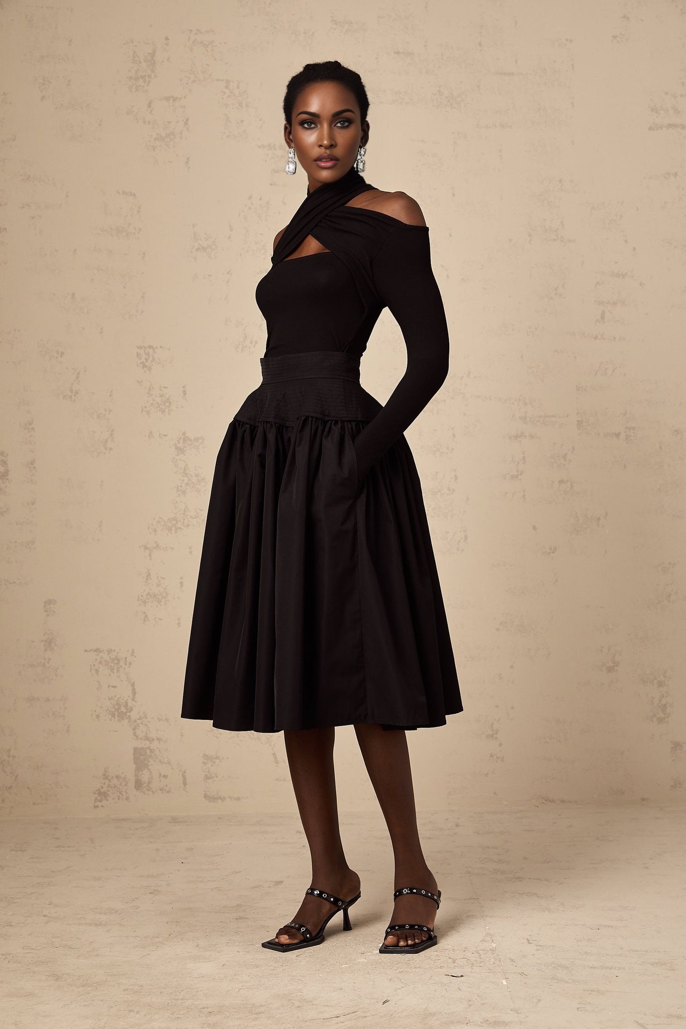 Black pleated midi skirt with flared silhouette named Pauline
